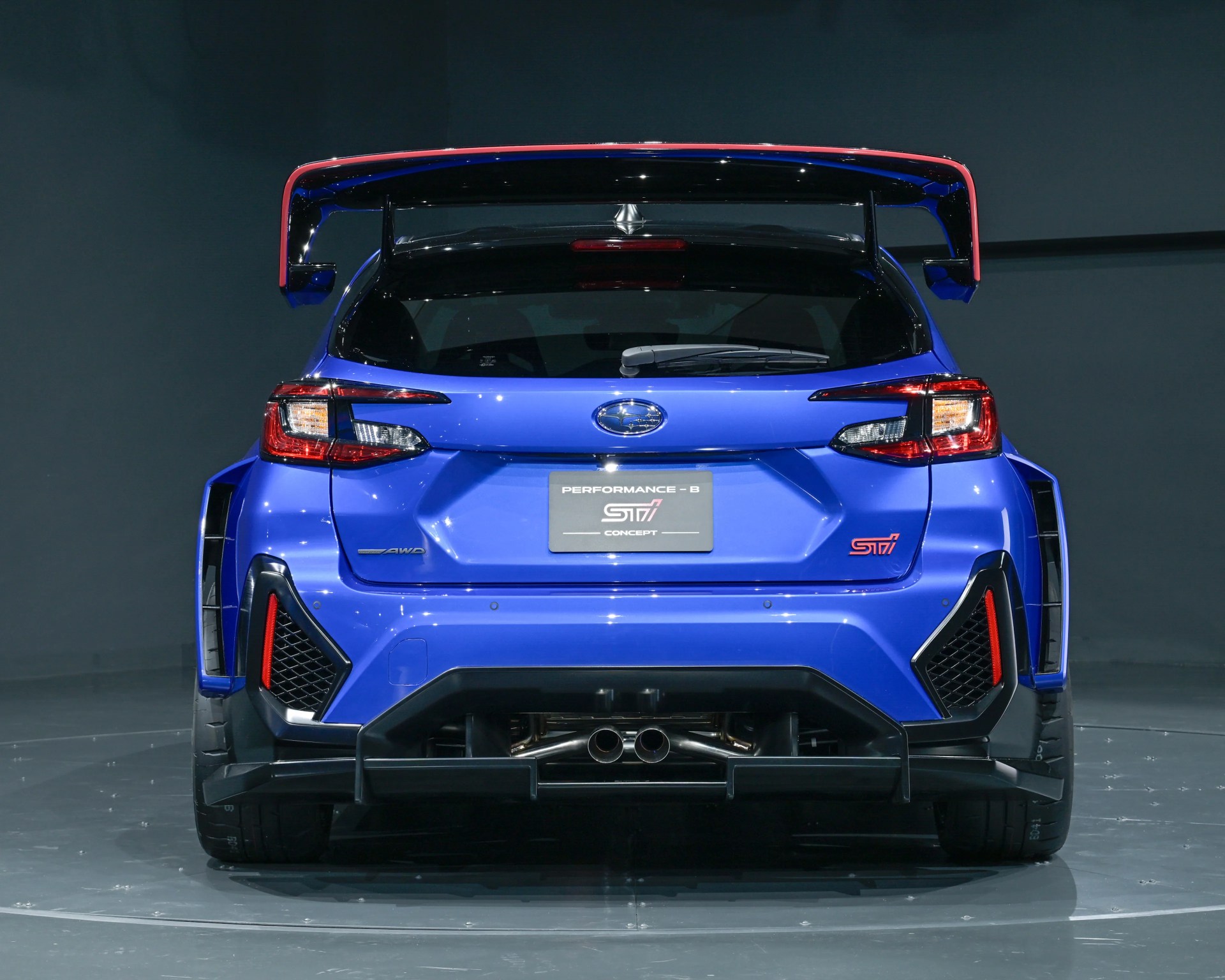 Rear view of a blue Subaru STI Performance-B Concept hatchback with large rear wing and dual exhaust.