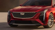 Front view of a red Cadillac car showing the grille with emblem, LED headlights, and alloy wheels.