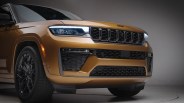 Front view of a gold Jeep SUV with LED headlights and black grille in a studio setting.