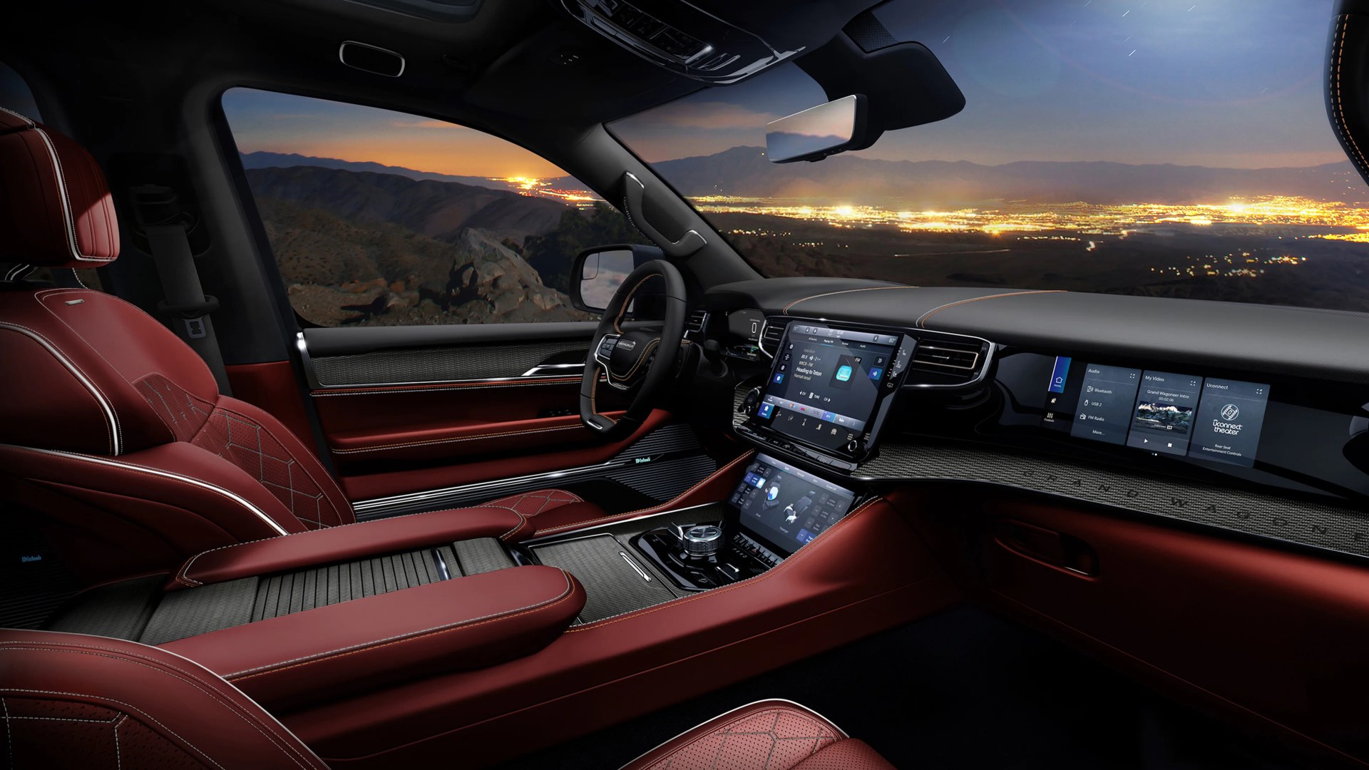Luxury car interior with red leather seats, dual touchscreen displays, and city lights visible through the window at dusk.