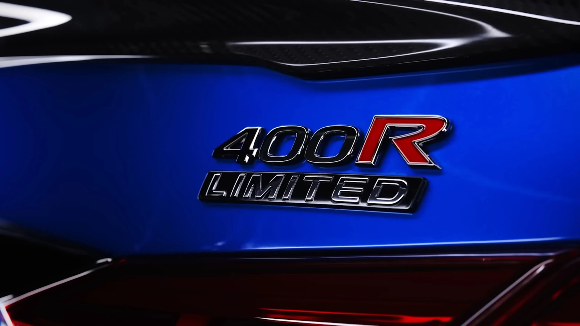 Close-up of a blue car rear with a "400R LIMITED" badge, featuring a red "R" and black and silver lettering.