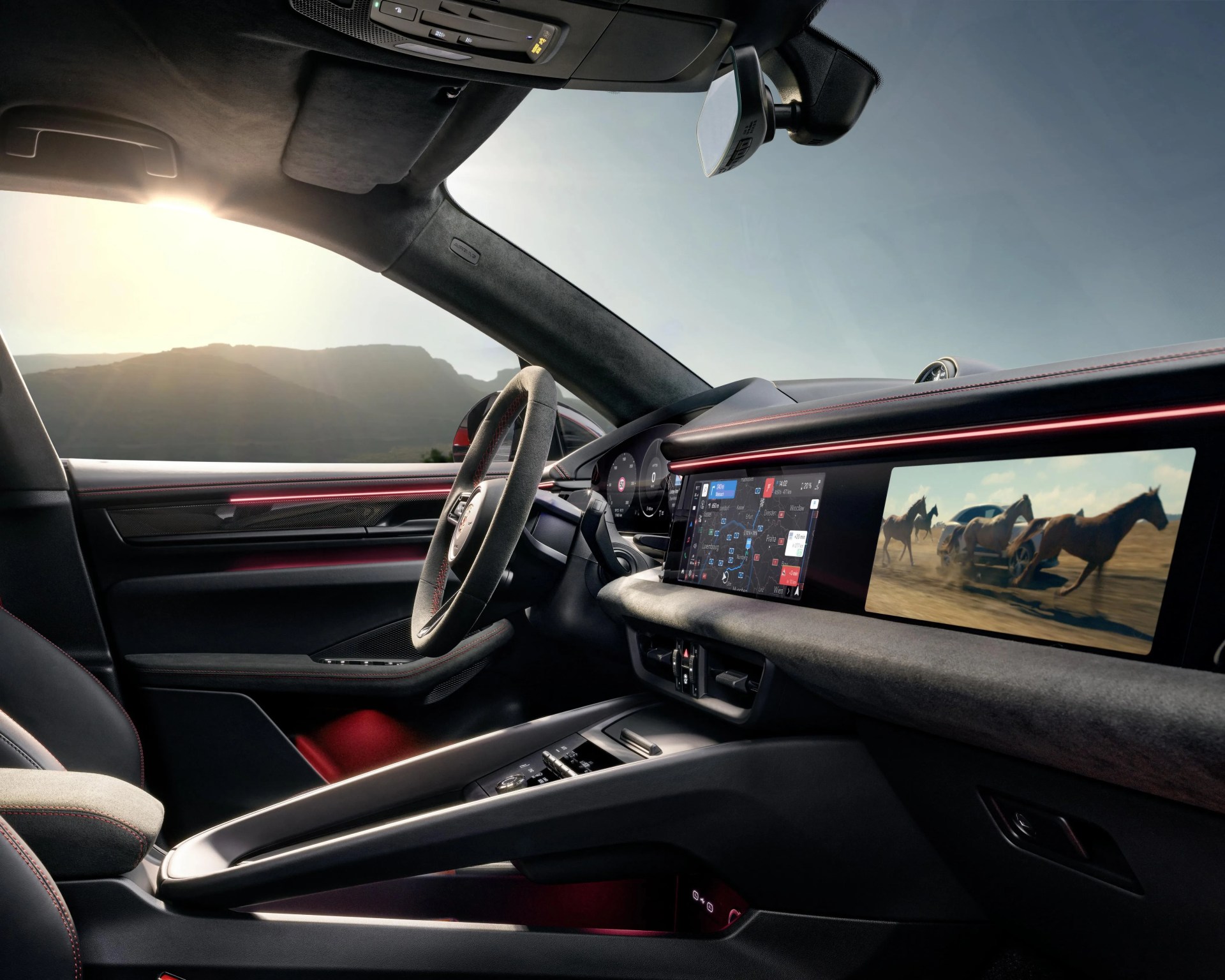 Interior of a modern car featuring a digital dashboard with navigation and video screens, black and red accents, and a suede steering wheel.