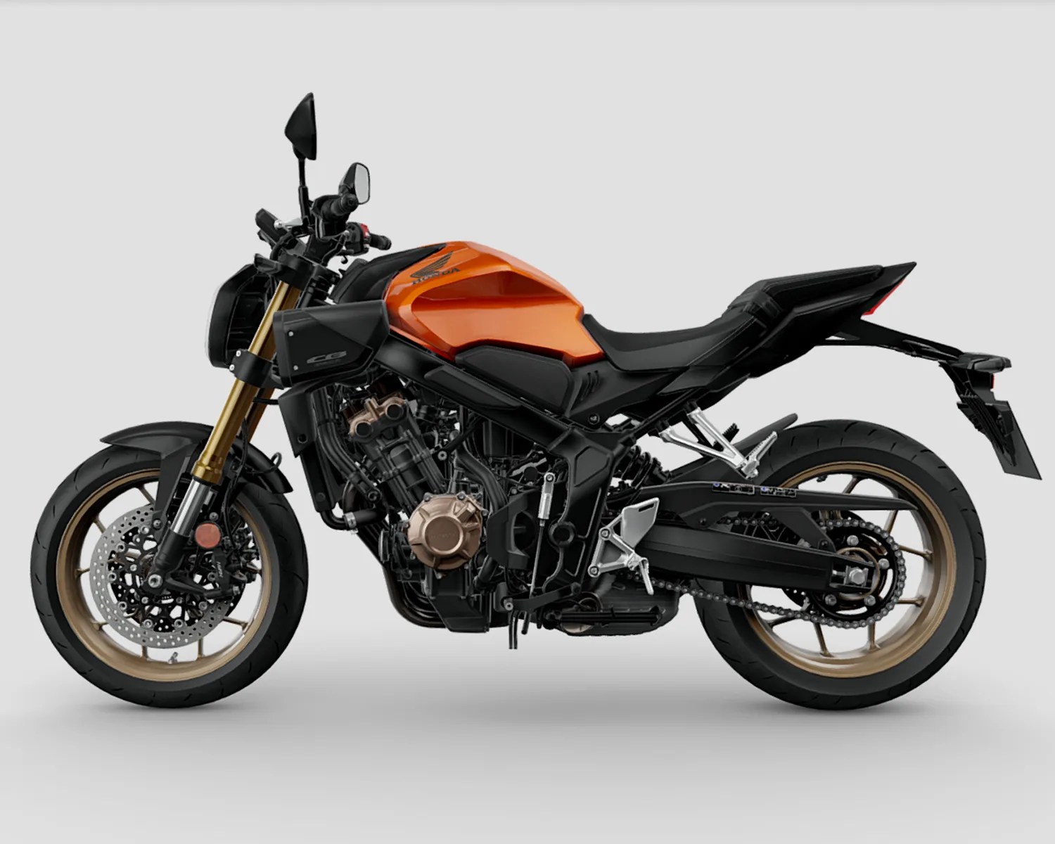 Orange and black Honda motorcycle with gold front forks and bronze wheels on a gray background.
