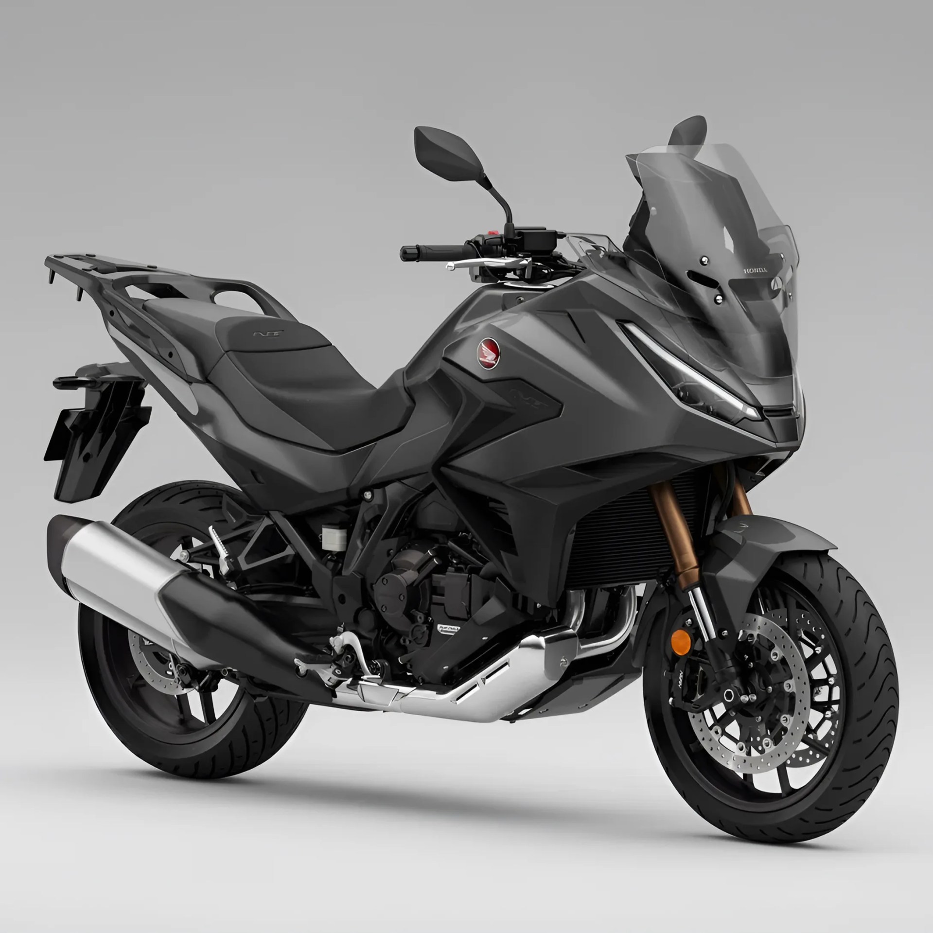 Matte gray Honda touring motorcycle with tall windshield and dual front disc brakes on a gray background.