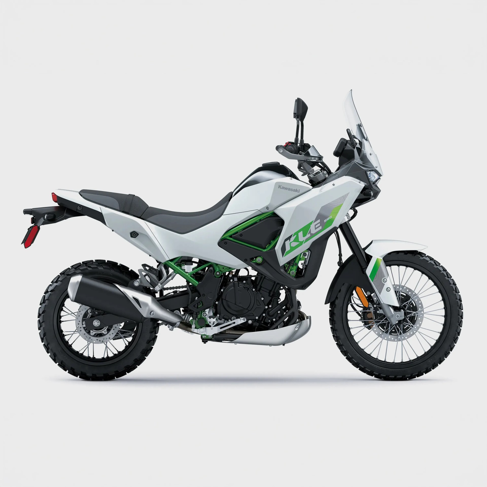 White and green Kawasaki KLE 500 dual-sport motorcycle with knobby tires and a tall windshield on a white background.
