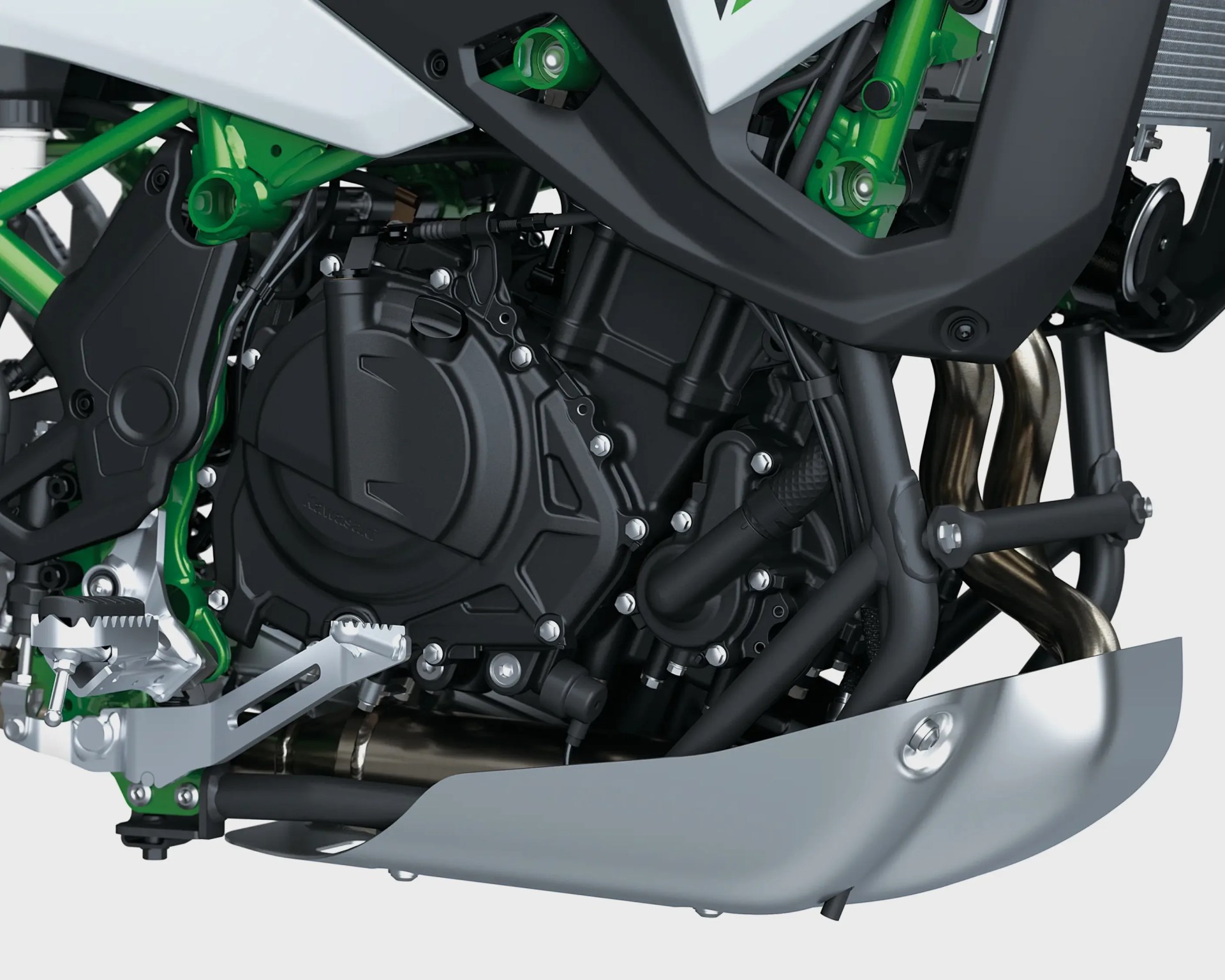 Close-up of a black motorcycle engine with green frame and silver foot pegs, showing exhaust pipes and skid plate.