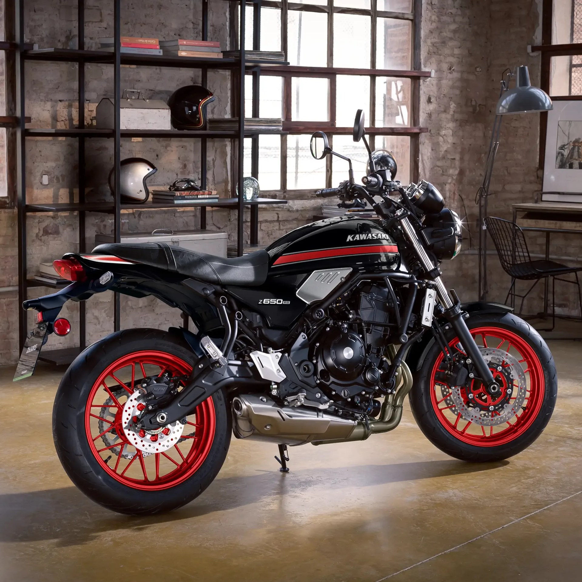 Black Kawasaki Z650 RS motorcycle with red wheels parked indoors on a polished concrete floor.