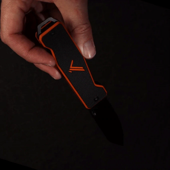 Hand holding a black and orange folding knife with a partially serrated blade opening against a dark background.