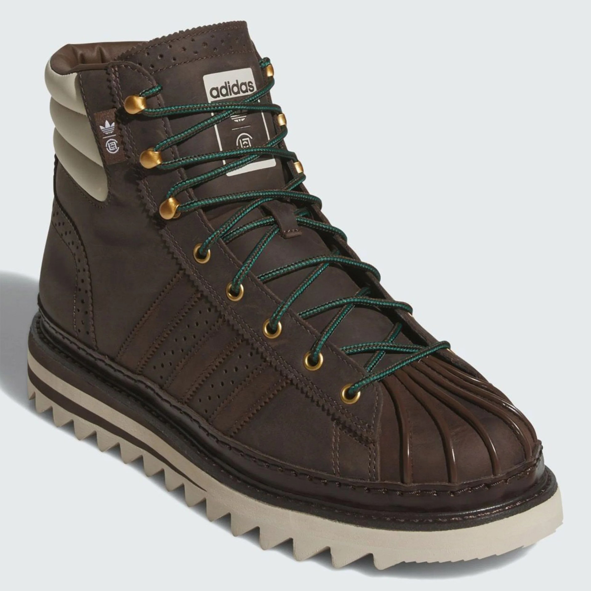 Dark brown Adidas high-top boot with green laces, ribbed toe cap, and beige padded collar and sole.
