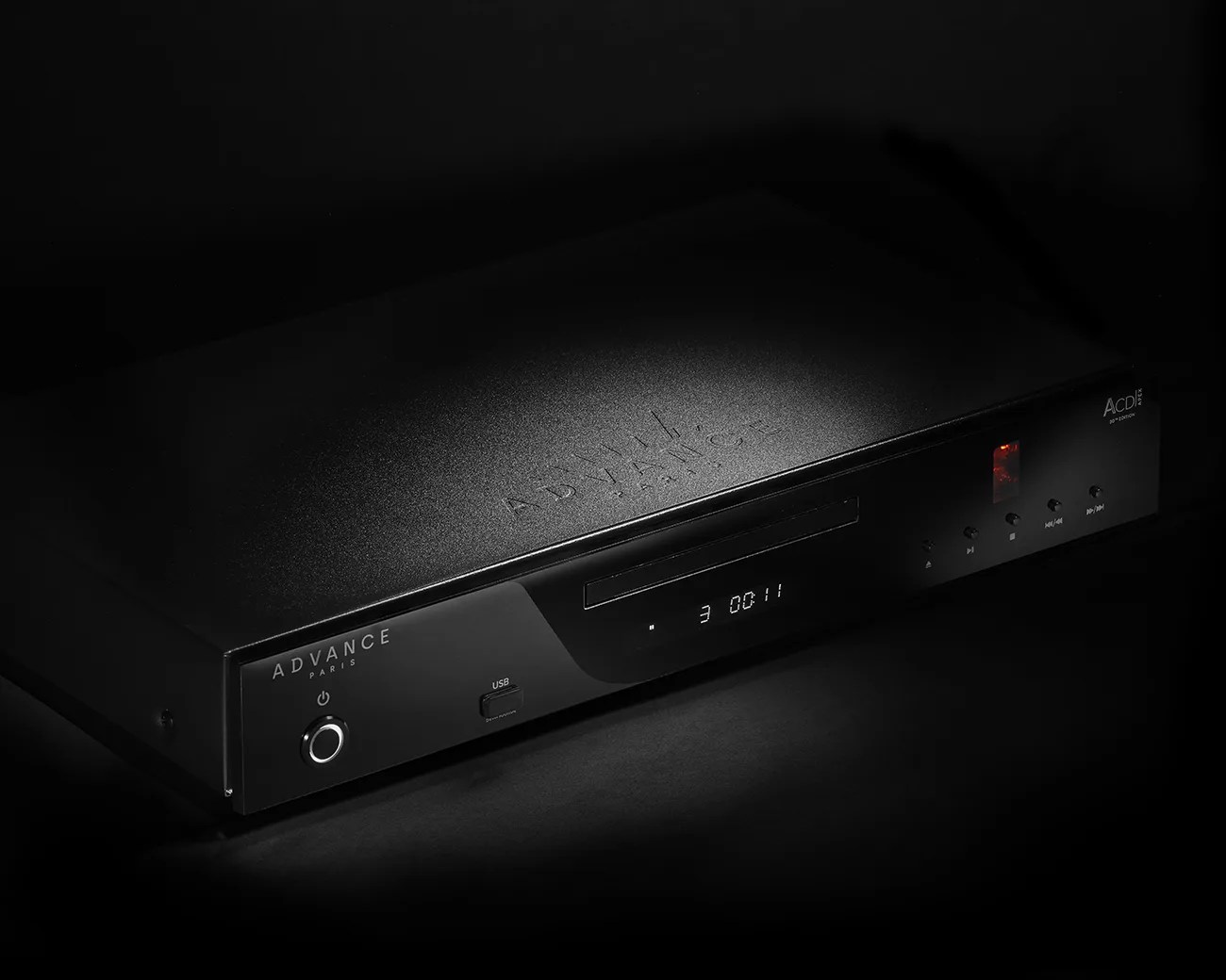 Black Advance Paris ACDi 2 CD player with illuminated display and control buttons in low light.