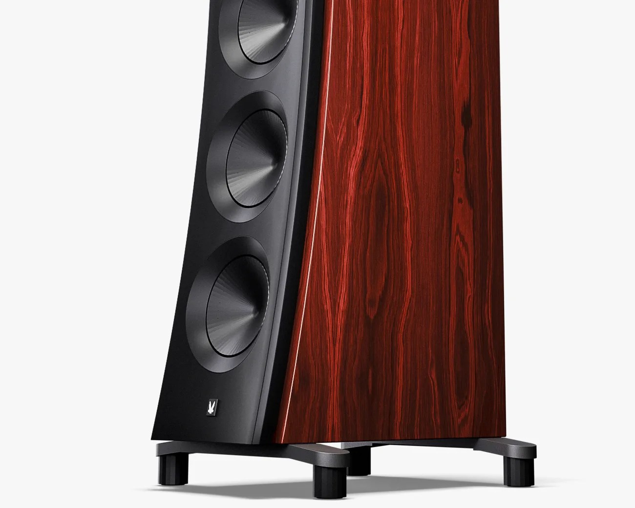 Floor-standing speaker with three black cone drivers and a dark reddish wood veneer cabinet on black feet.
