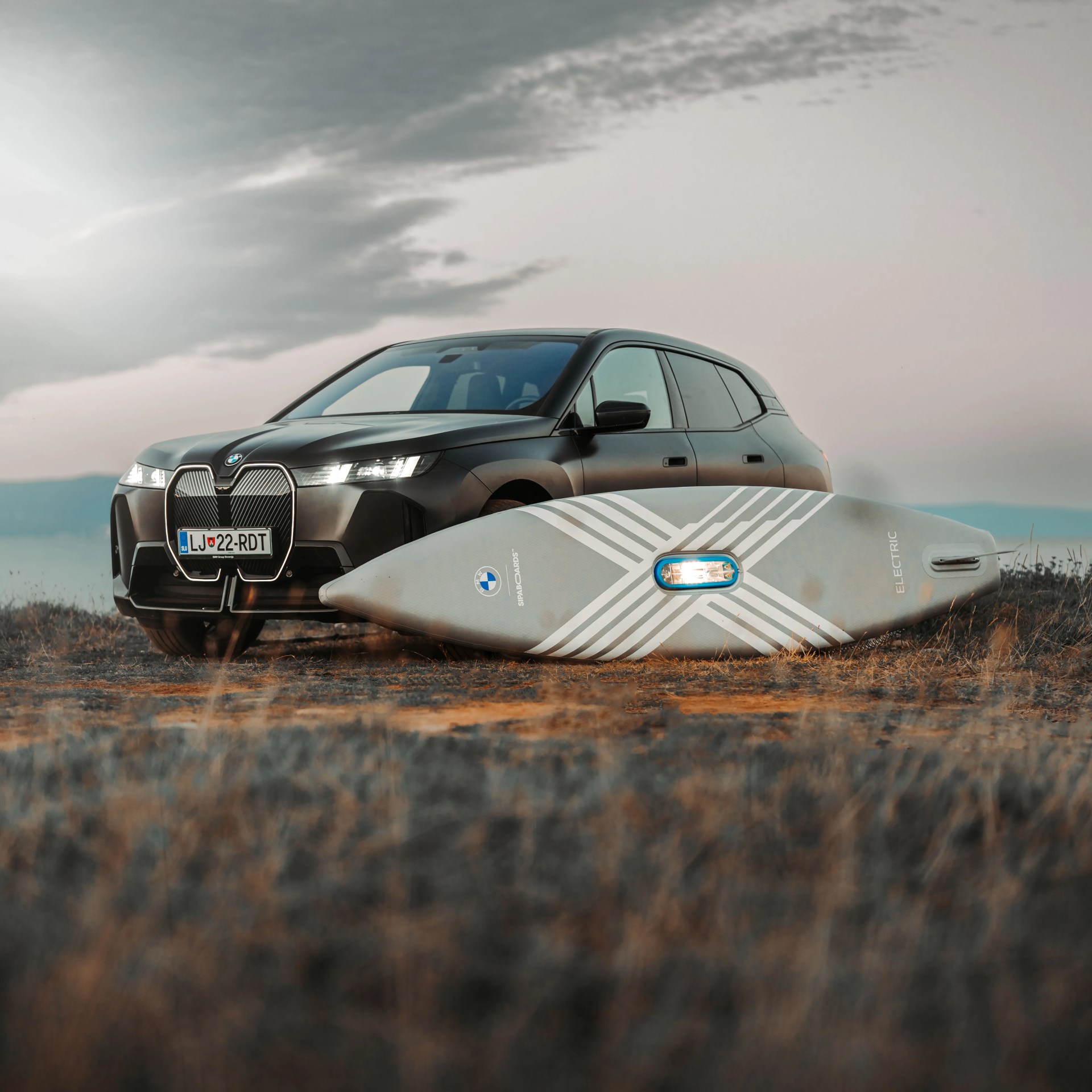 a photo of an electric bmw suv with an electric stand-up paddleboard