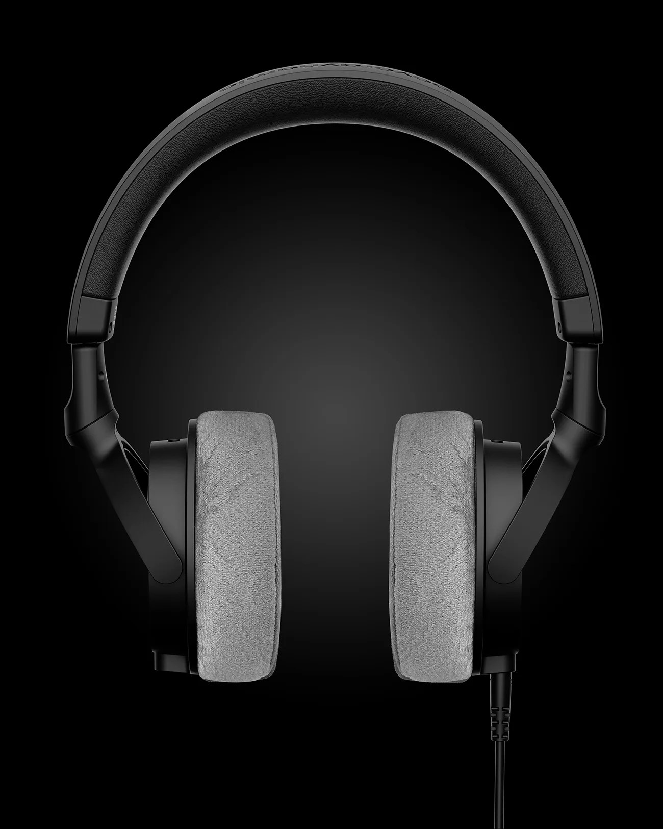 Black over-ear headphones with gray cushioned ear pads and a padded headband on a black background.