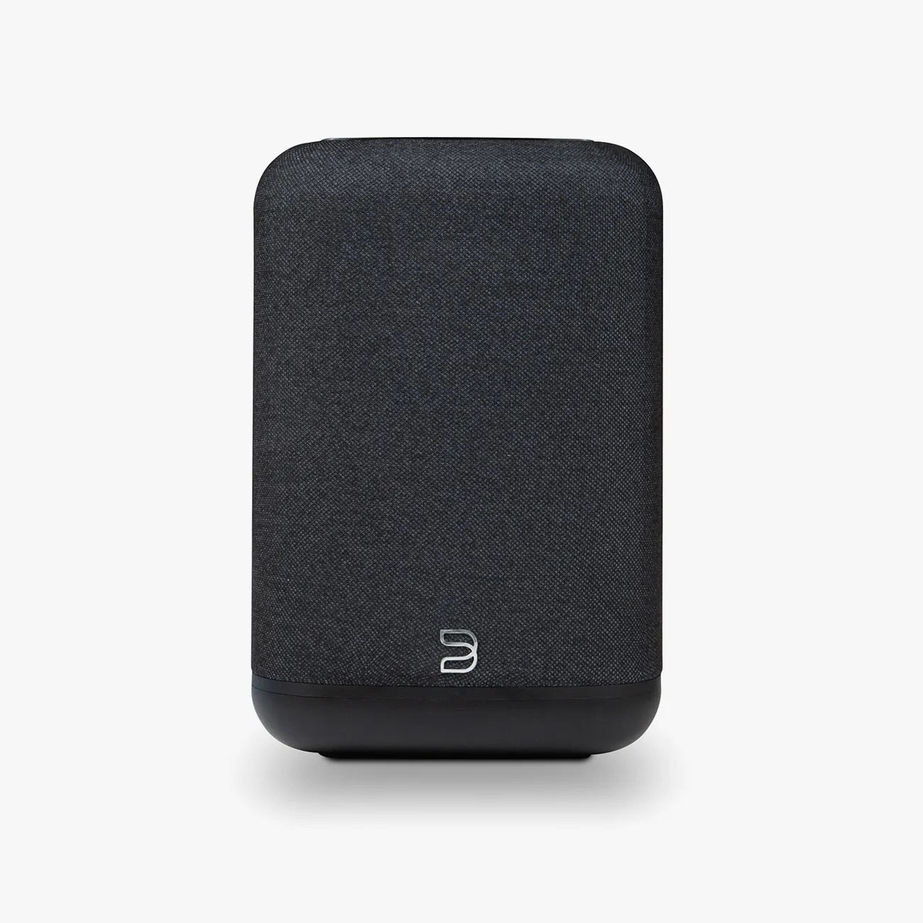 Compact black fabric-covered wireless speaker with rounded edges and a small silver logo near the bottom.