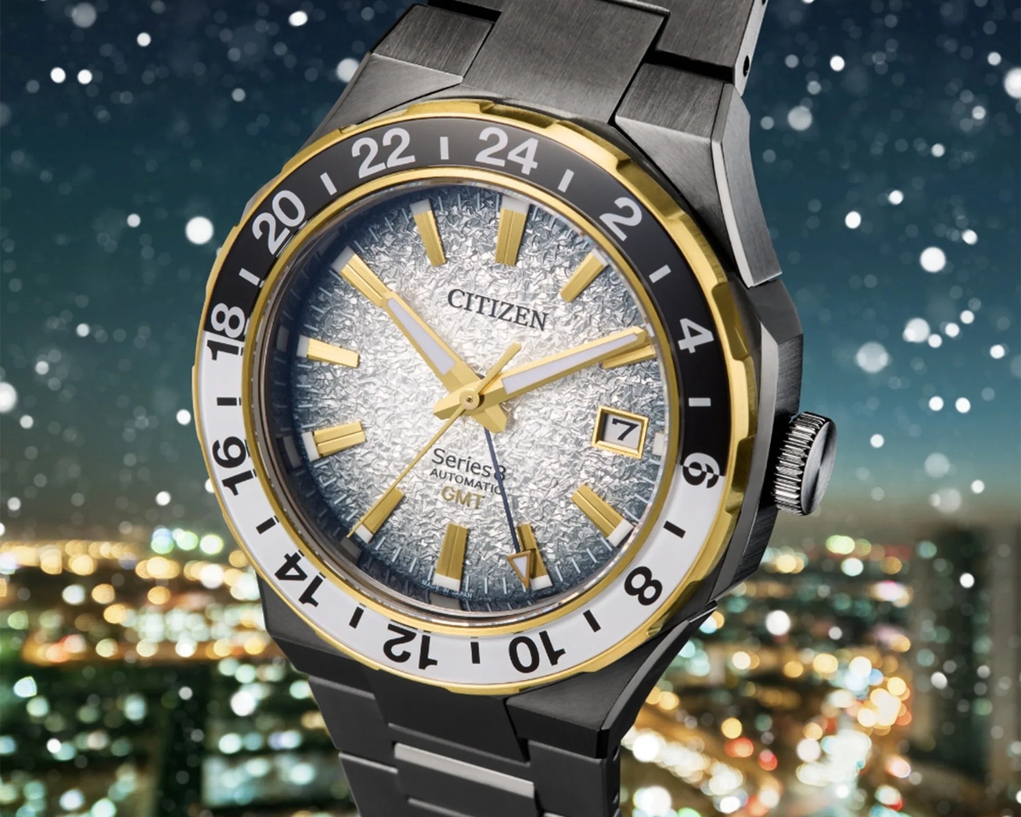 Citizen Series 8 GMT watch with textured silver dial, gold-tone markers, black and white 24-hour bezel, and metal bracelet.