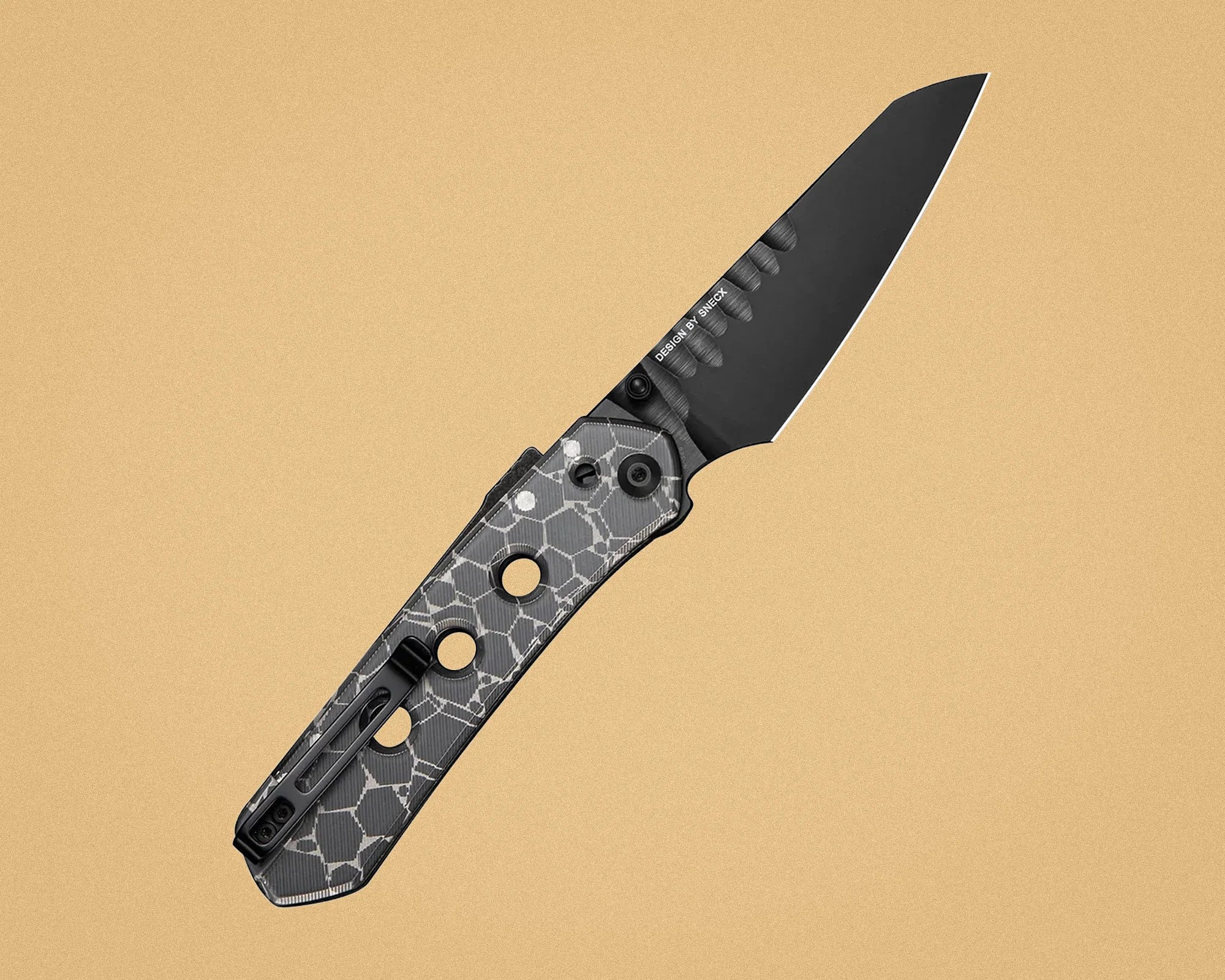 Folding knife with black blade and gray patterned handle featuring circular cutouts and a pocket clip.