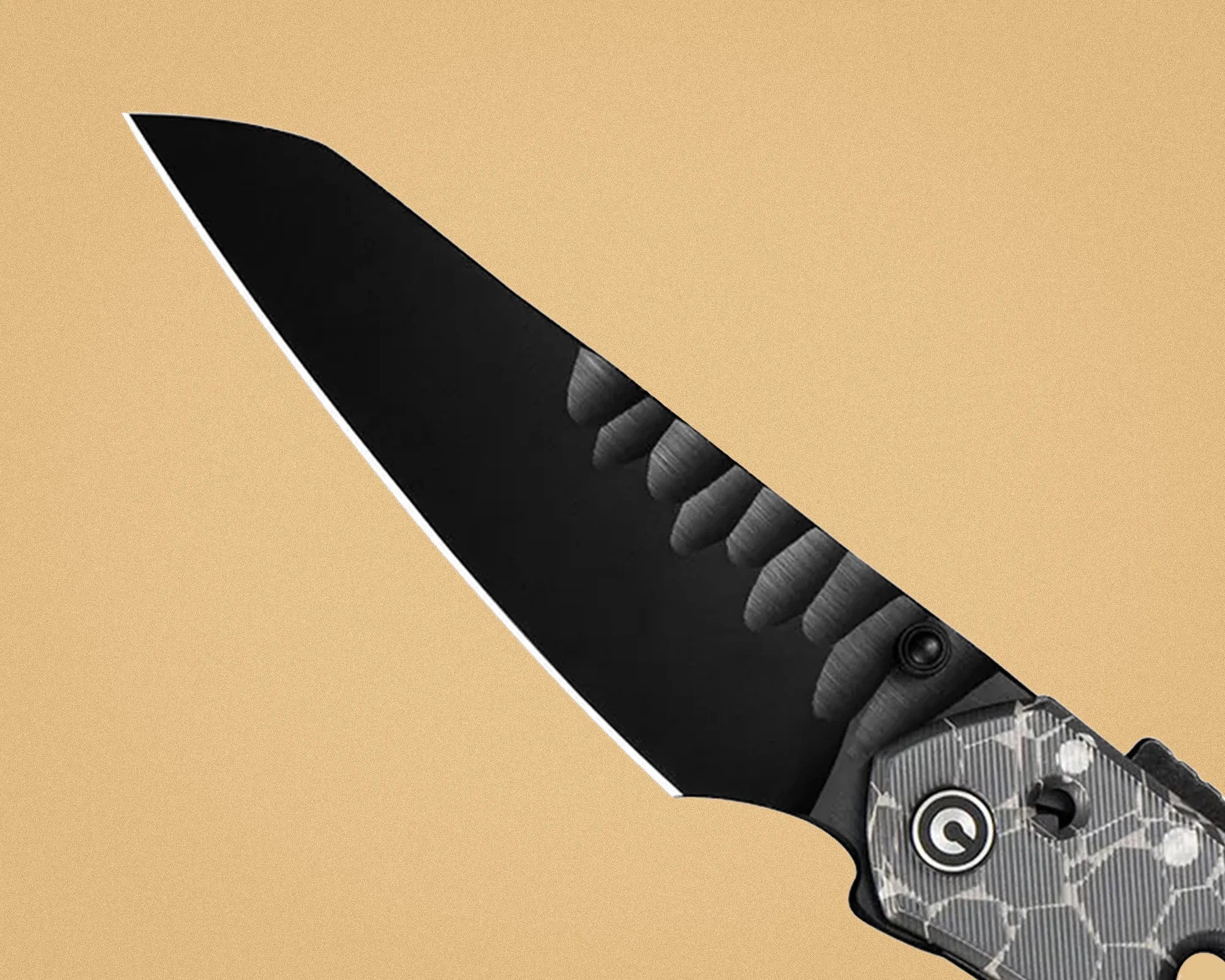 Black tanto-style folding knife blade with textured spine and gray patterned handle.