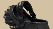 Black Crocs clog with camouflage-patterned tread and adjustable black strap.