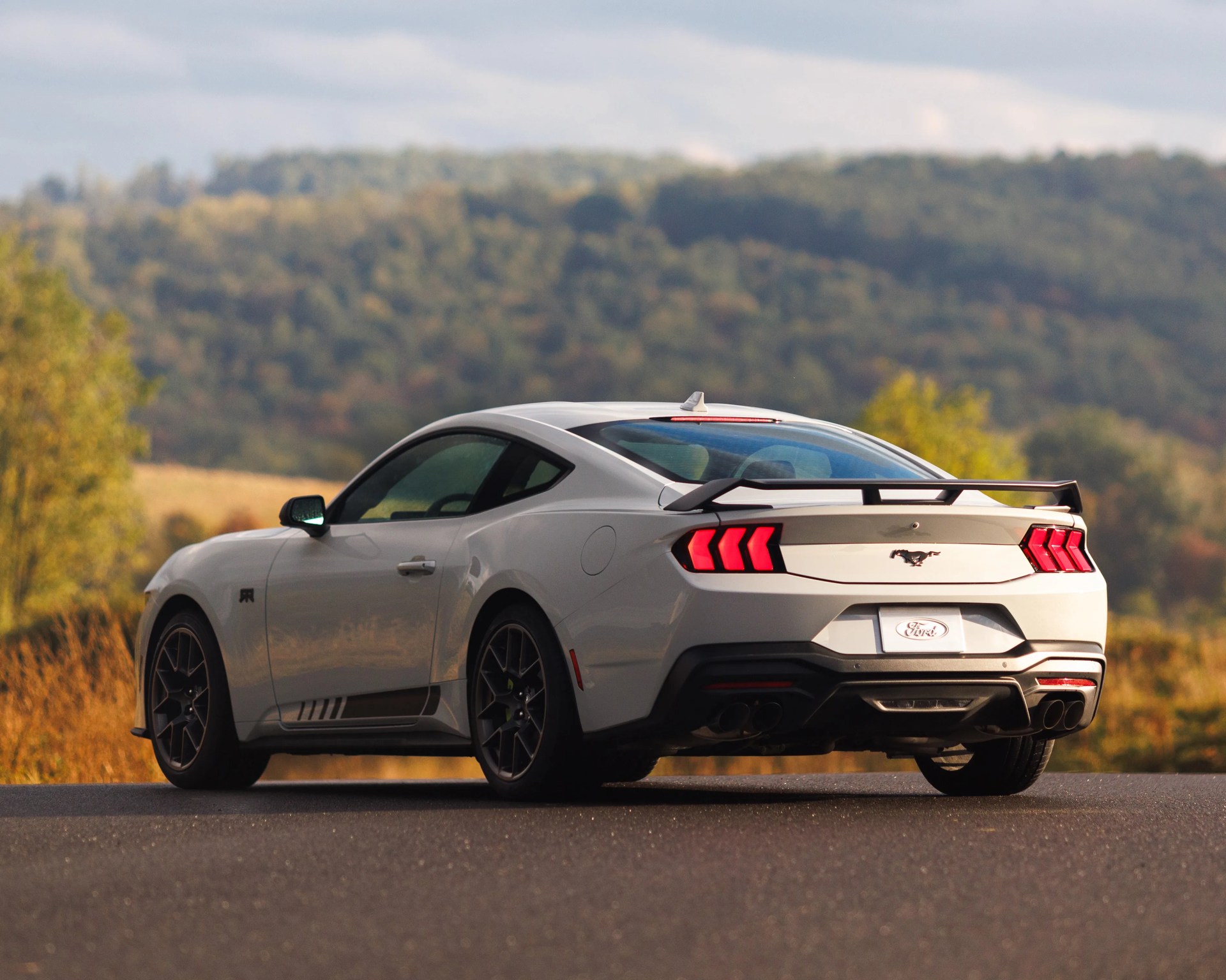White Ford Mustang RTR parked in front of fall backdrop