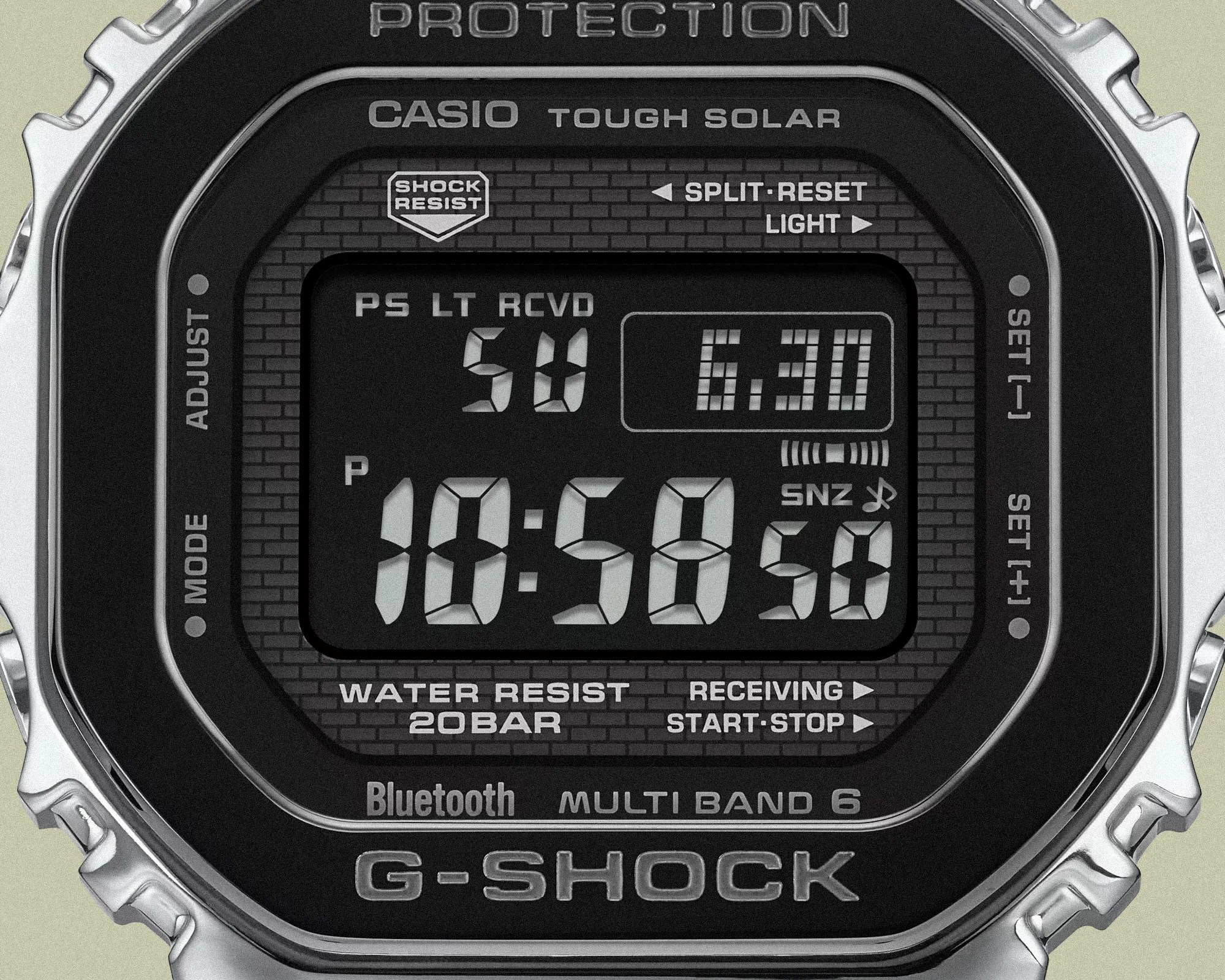 Digital display of a Casio G-Shock Tough Solar watch showing time 10:58:50 with stainless steel bezel.