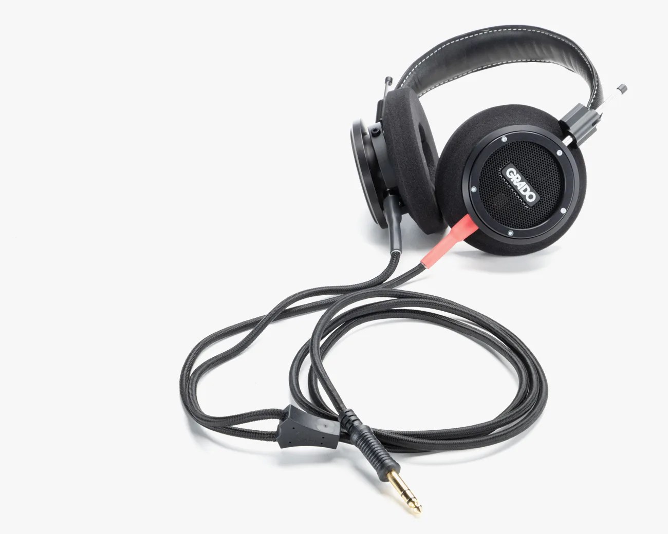 Black Grado over-ear headphones with foam ear pads and coiled audio cable with gold 3.5mm plug.