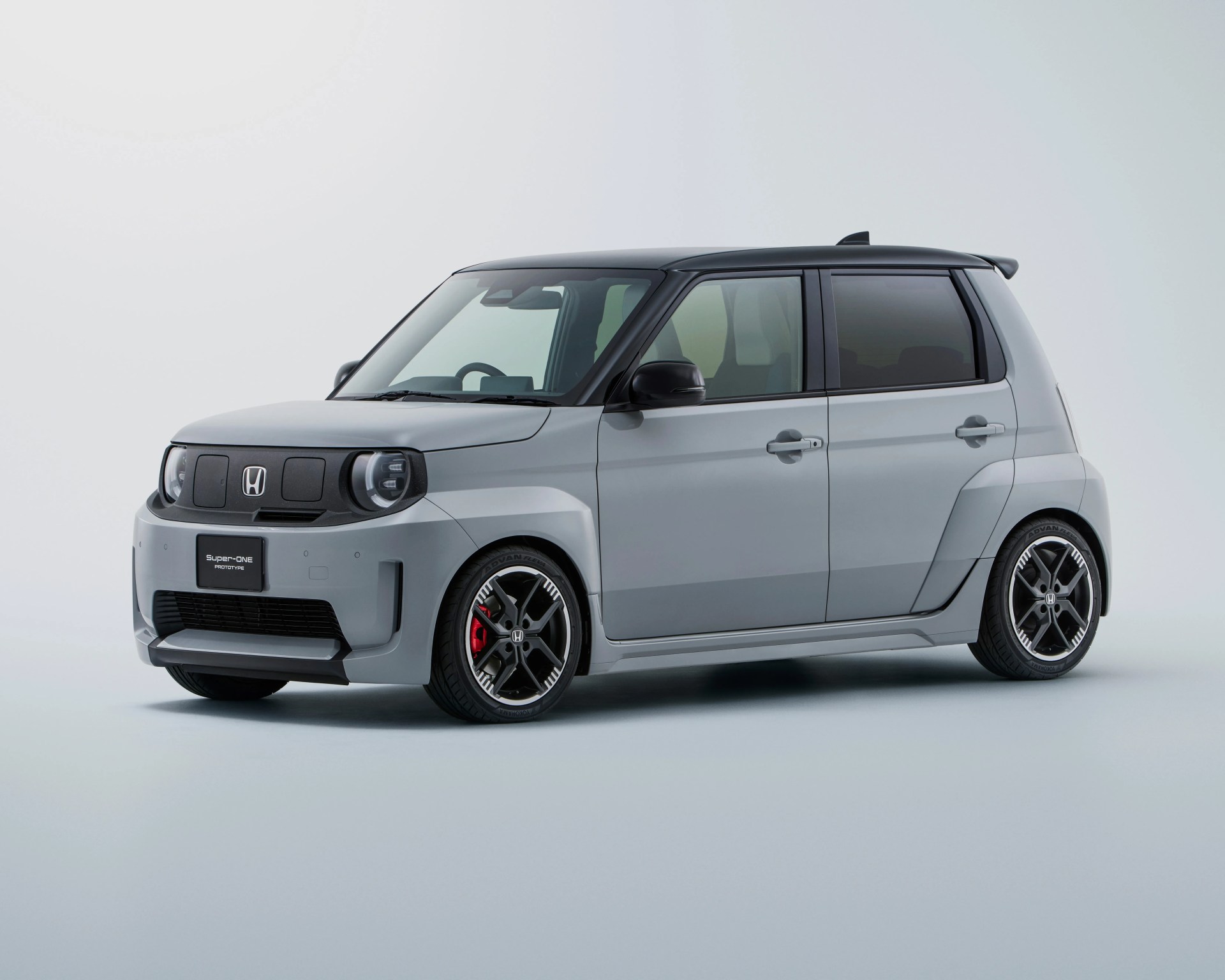 Compact gray Honda Super-ONE prototype car with black roof and sporty black alloy wheels on a white background.