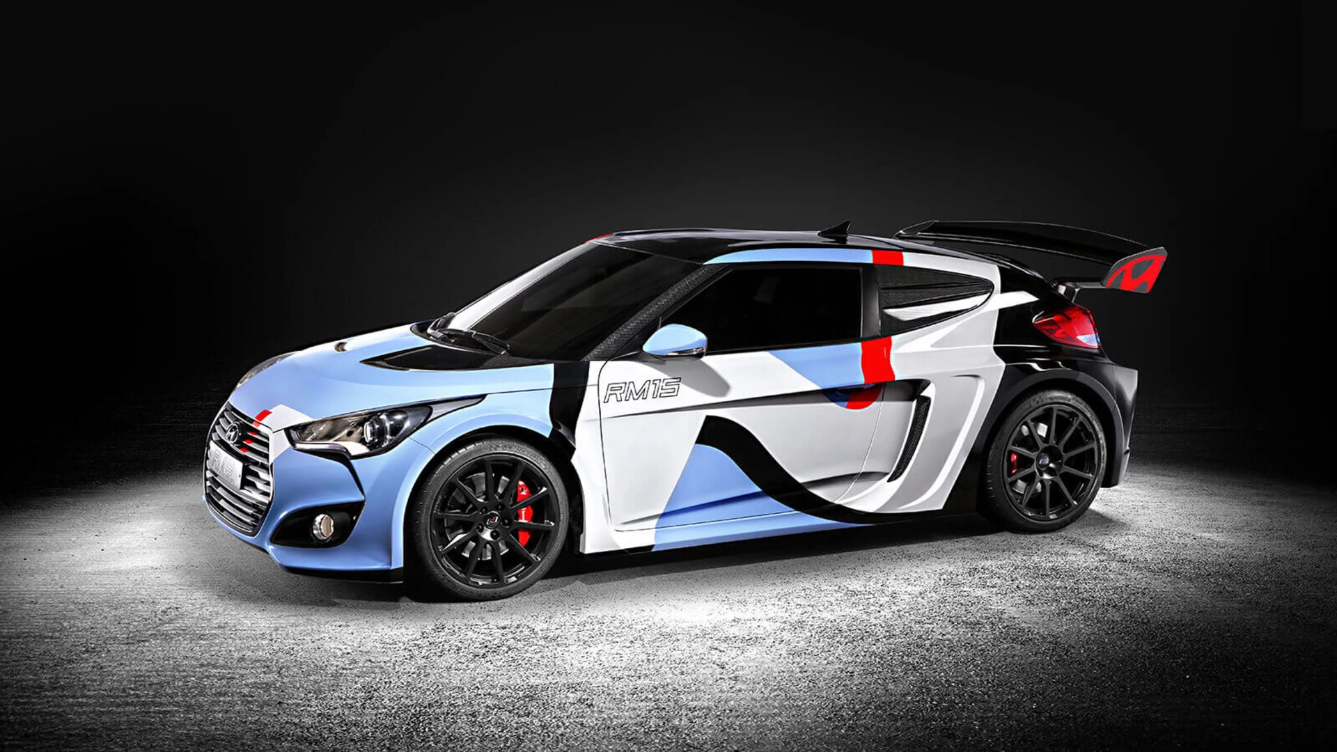 Hyundai RM15 sports car with a blue, white, black, and red geometric paint design and black wheels.