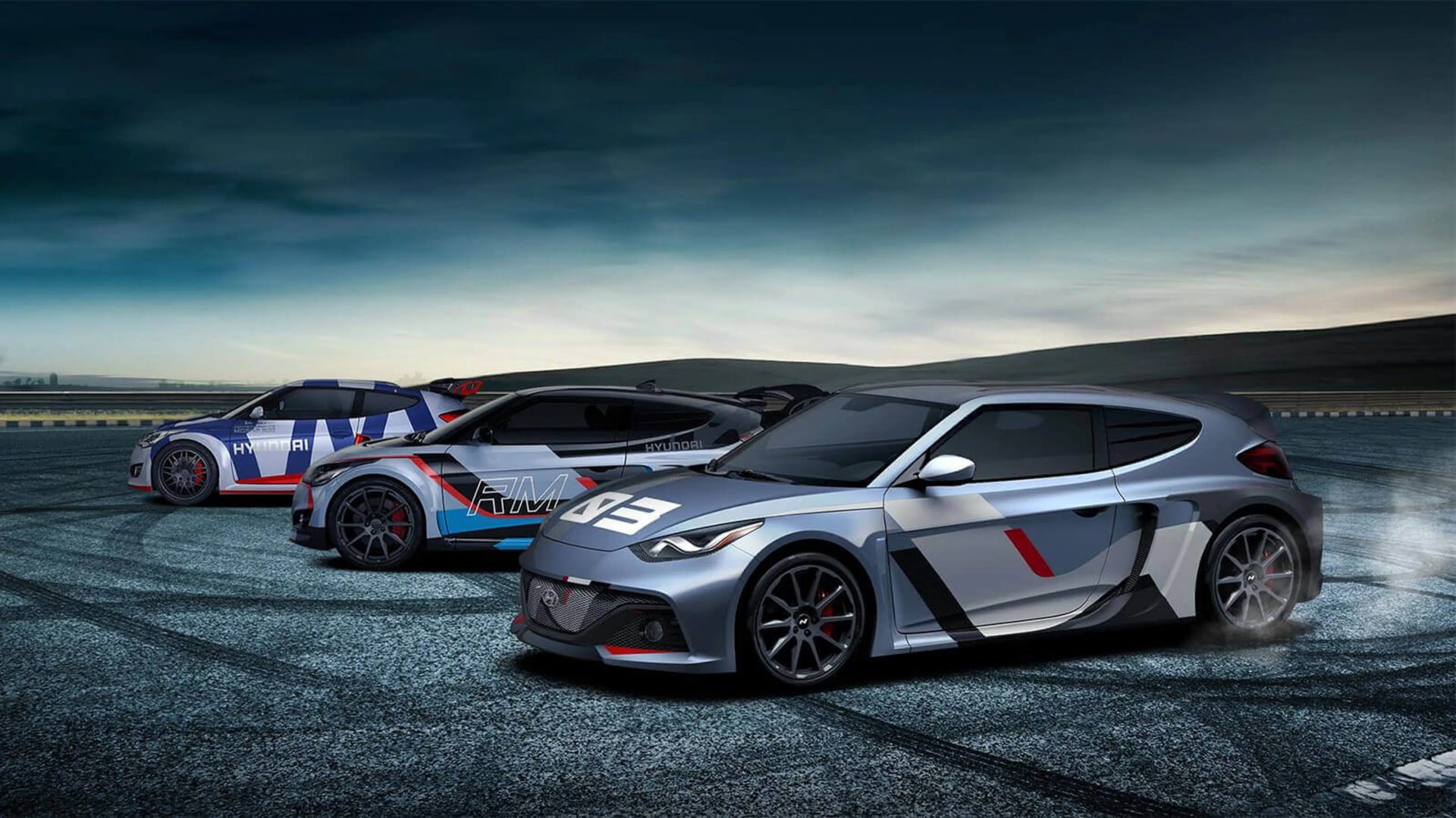 Three sporty Hyundai cars with racing decals drifting on a track under a cloudy sky.