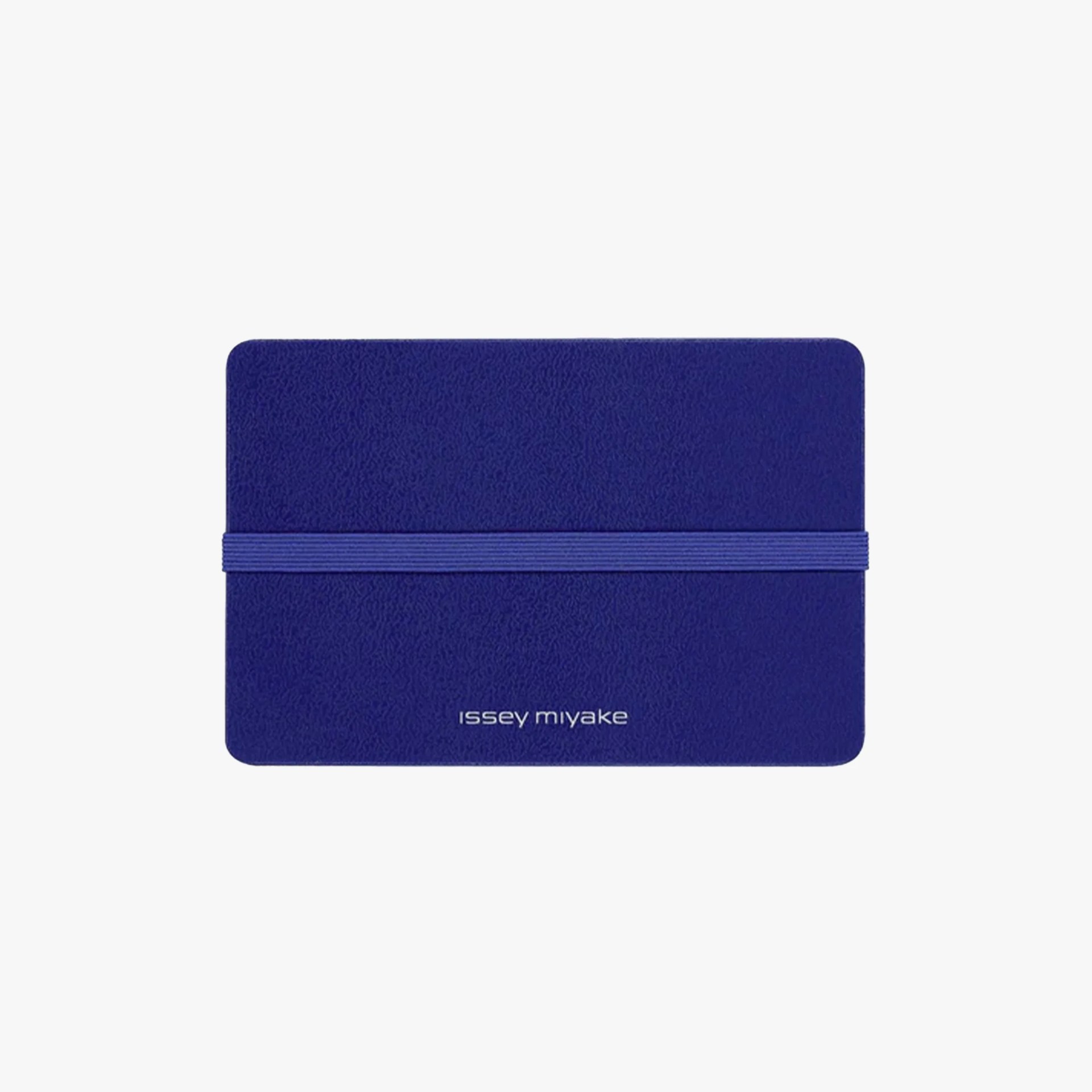 Blue textured notebook with elastic band and "issey miyake" logo on the cover.