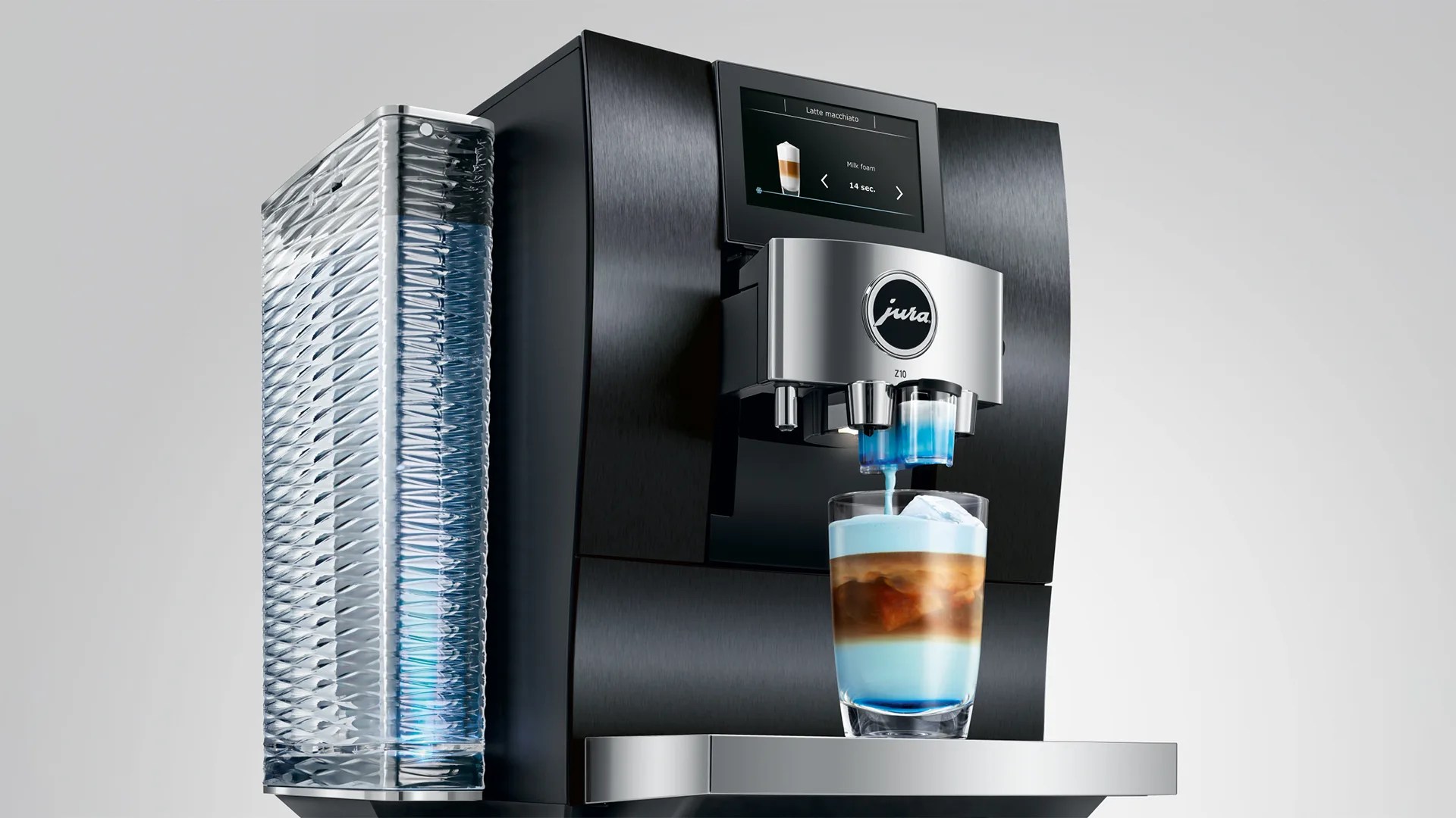 Black and silver Jura Z10 coffee machine dispensing a layered latte macchiato with blue foam into a glass.