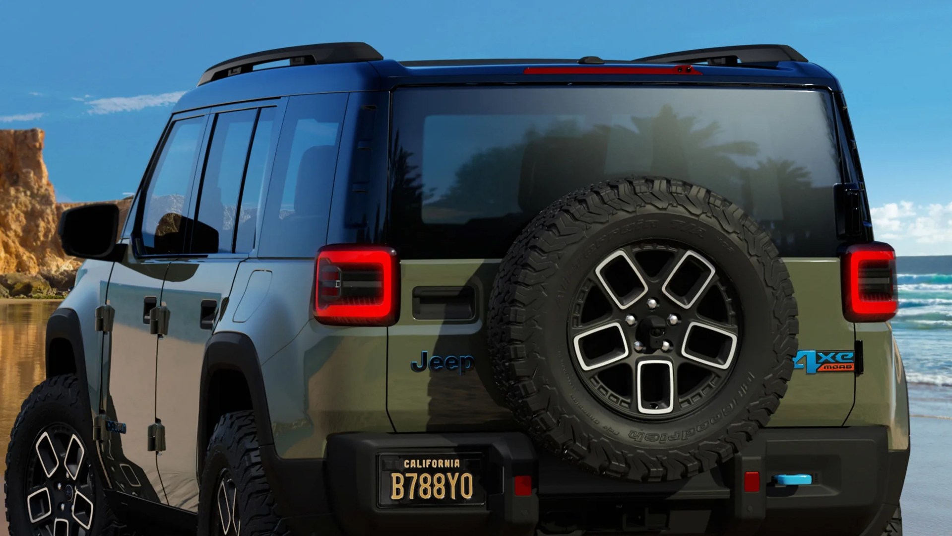 Green and black Jeep 4xe 4-door SUV with spare tire mounted on the rear, parked on a beach.