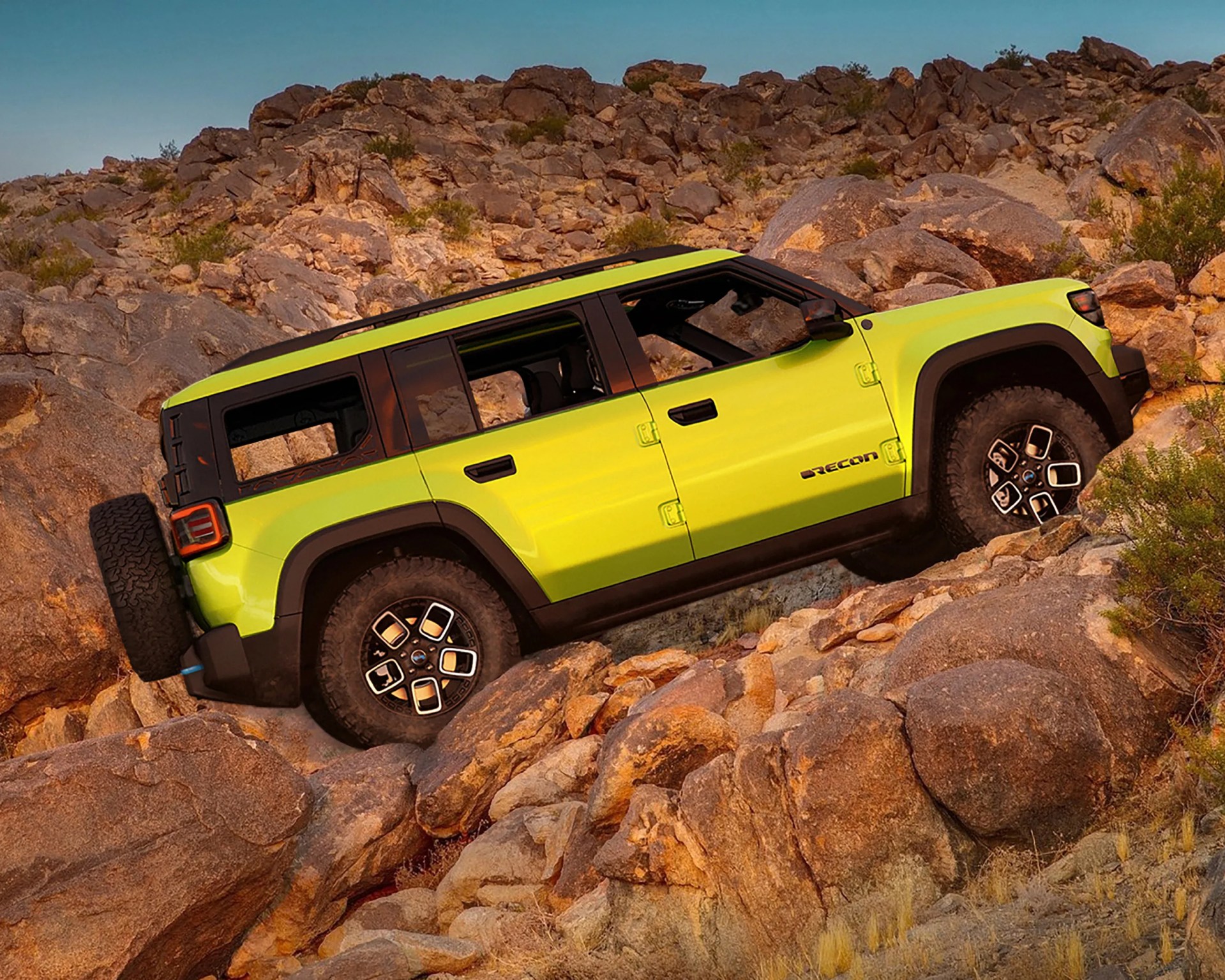 Bright green four-door off-road SUV with black trim climbing rocky terrain.