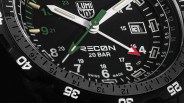 Close-up of a black Luminox Recon 20 BAR watch face with white and green hands and a red-tipped second hand.