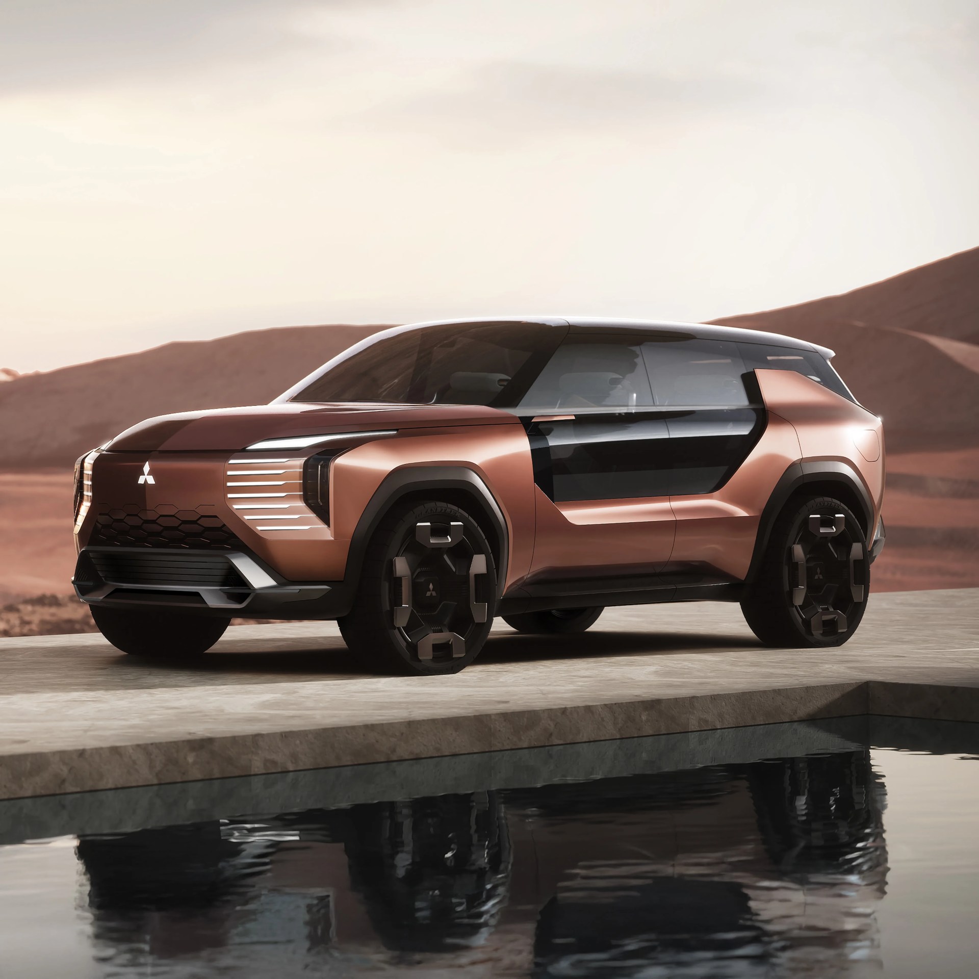 Copper-colored futuristic Mitsubishi SUV with black tinted windows and geometric wheel design parked near water.