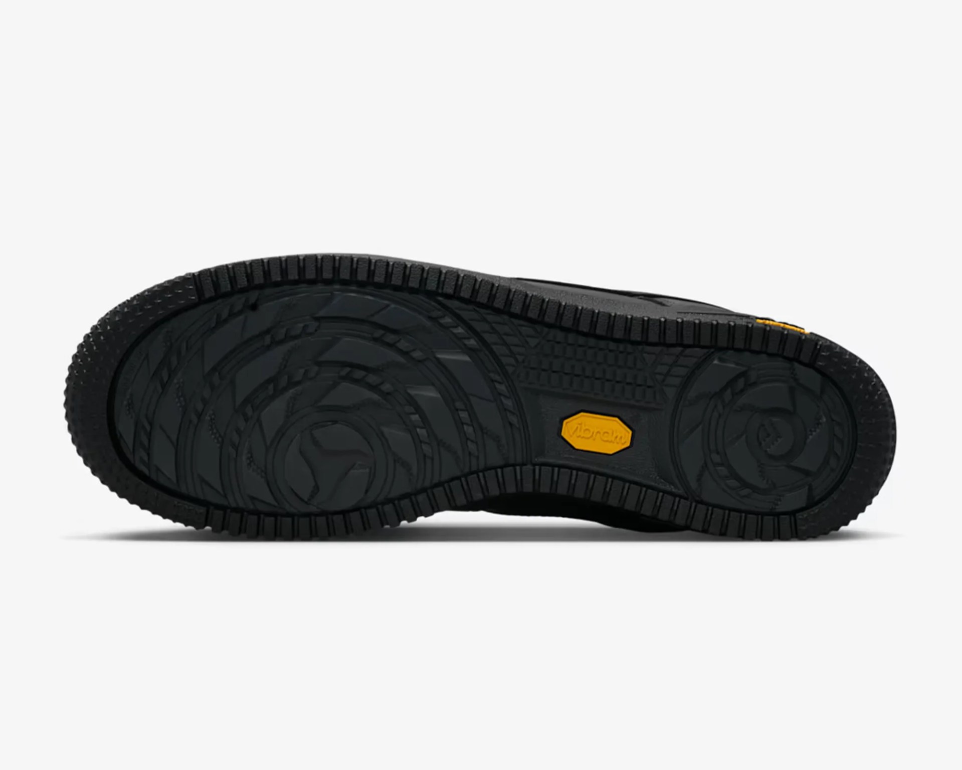 Black shoe sole with intricate tread pattern and a yellow Vibram logo in the center.