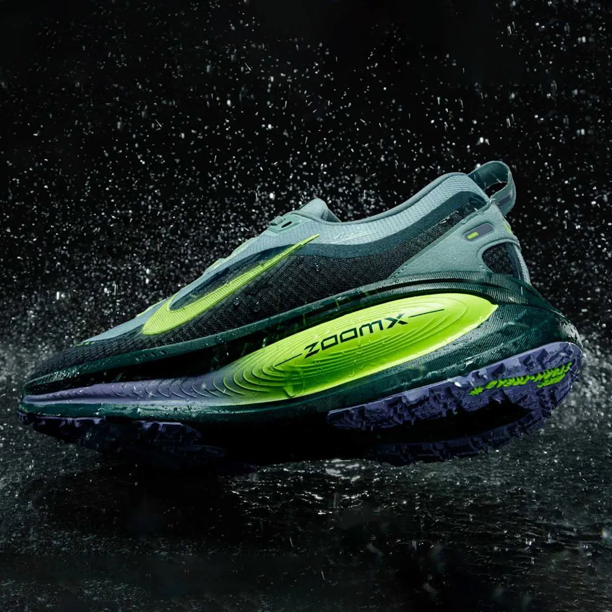 Dark green and neon yellow Nike ZoomX running shoe with water droplets and a black background.