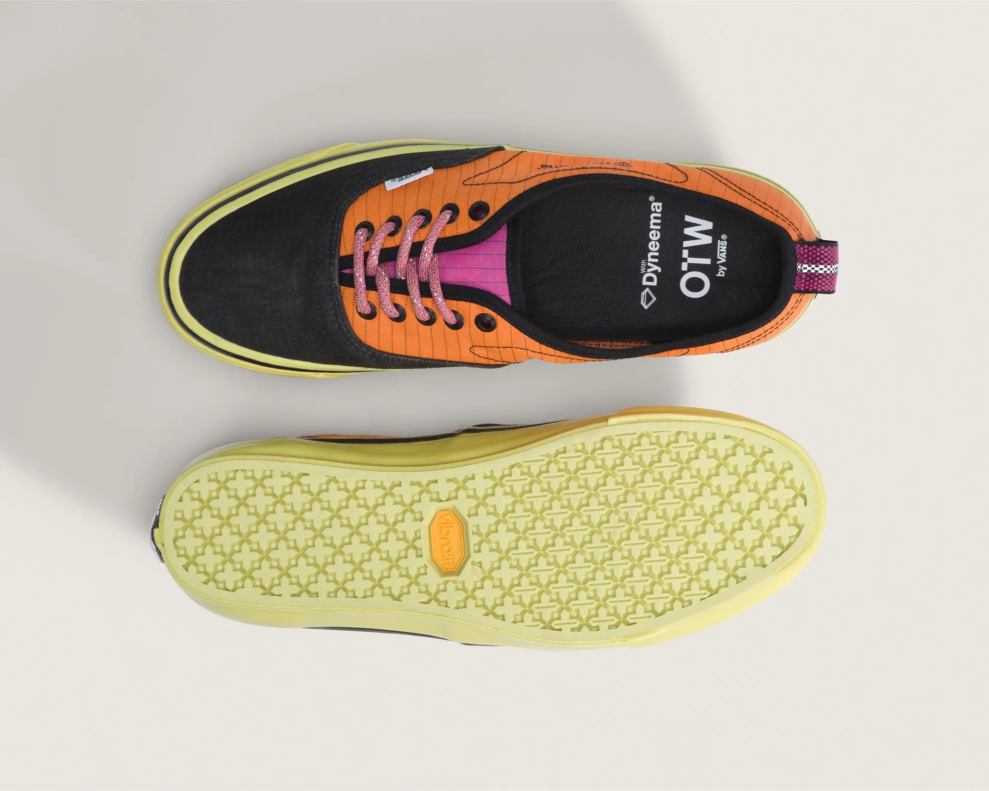 Pair of low-top sneakers with black toe caps, orange sides, pink laces, and yellow soles, one showing the top and the other the sole.
