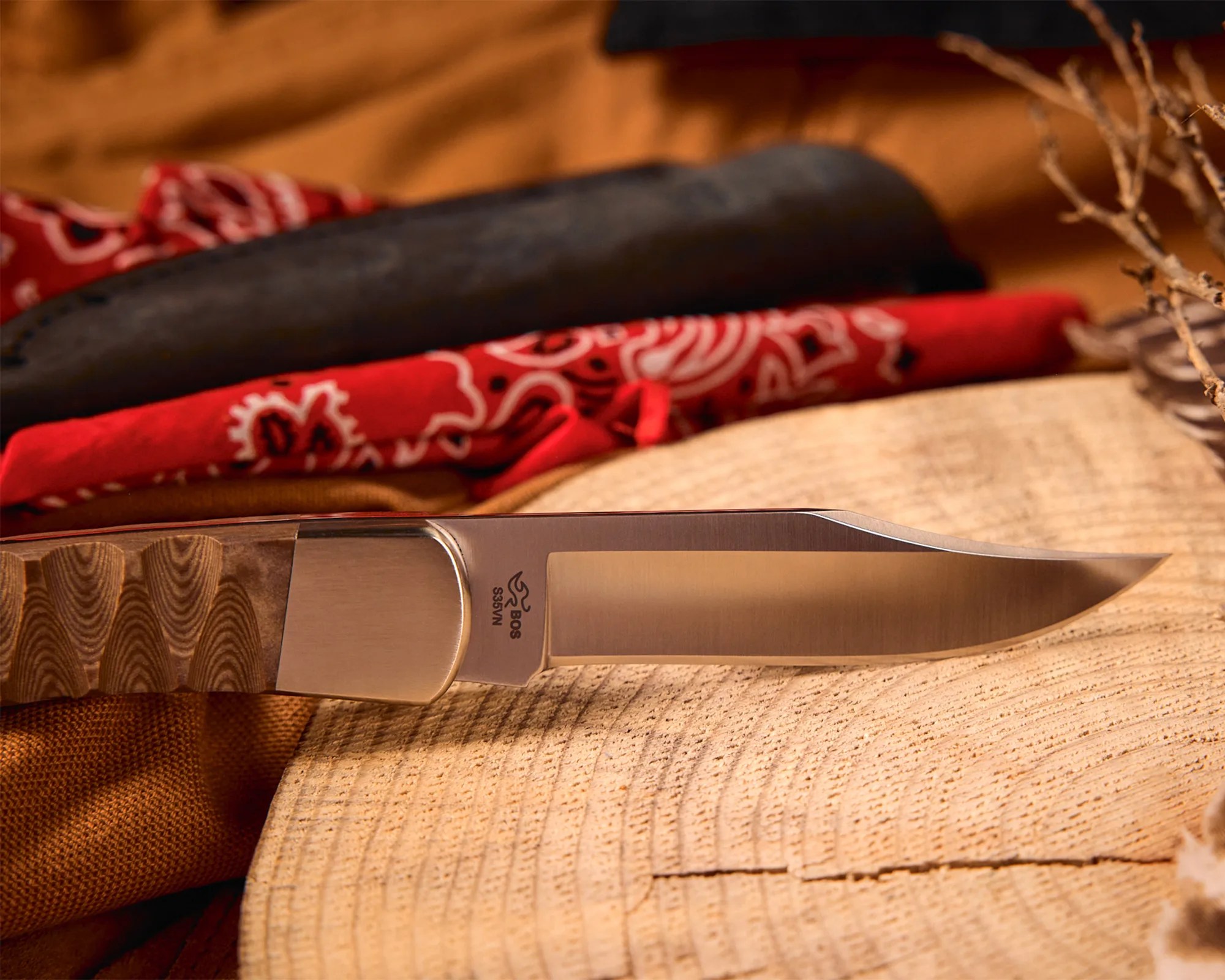 Knife with a polished stainless steel blade and a textured wooden handle resting on a wooden surface.