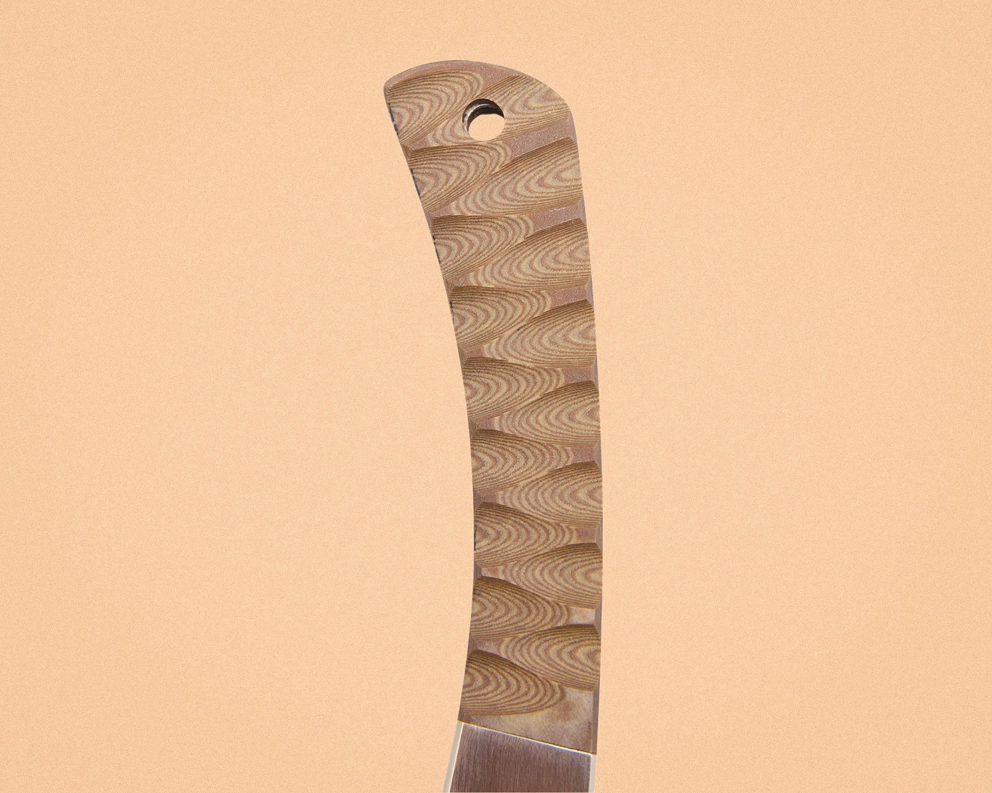 Close-up of a knife handle with a textured wood grain pattern and a hole near the top.
