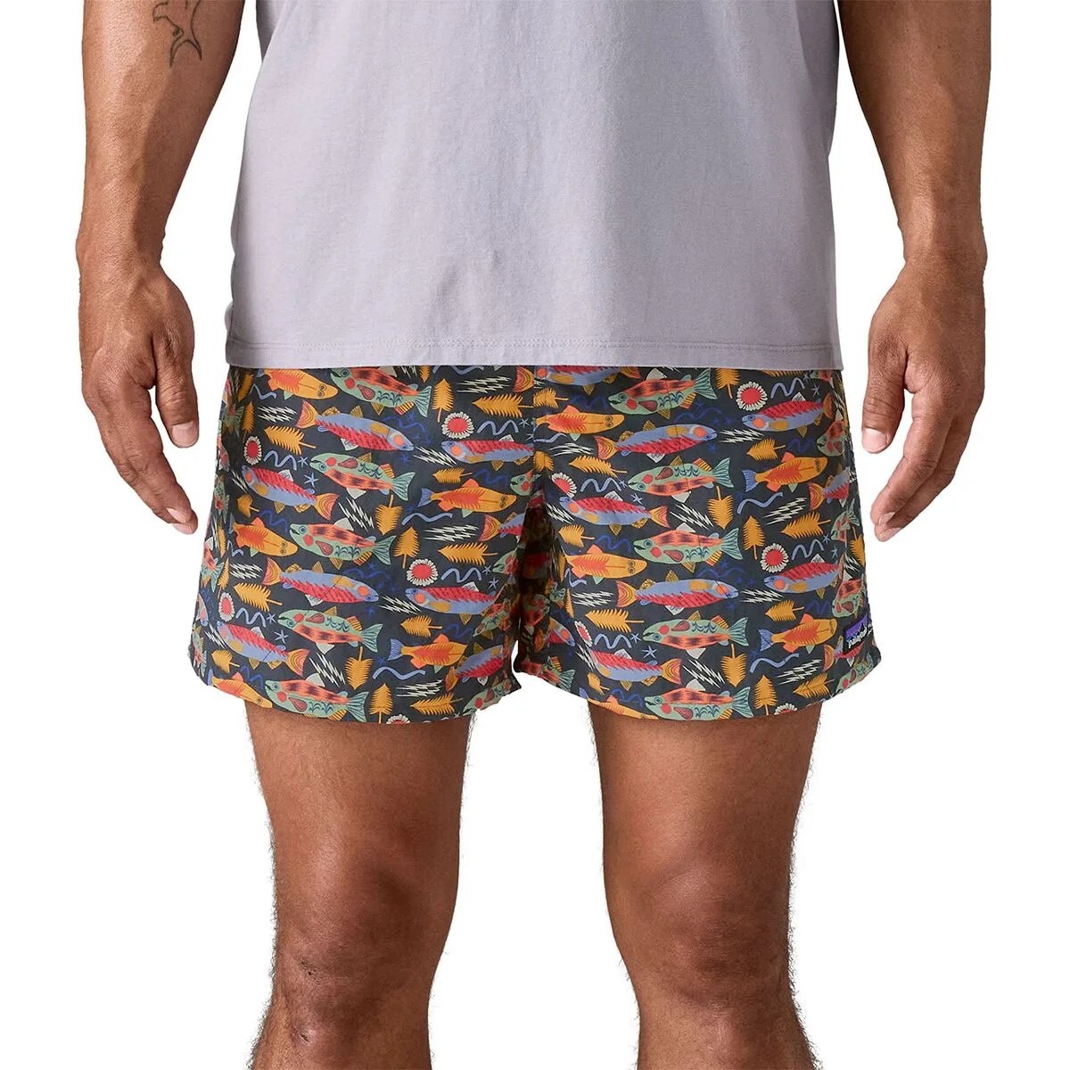 Men's swim shorts with colorful fish and seaweed pattern on a dark background.