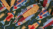 Fleece jacket with colorful fish pattern, tan snap-button placket, and Patagonia logo patch.