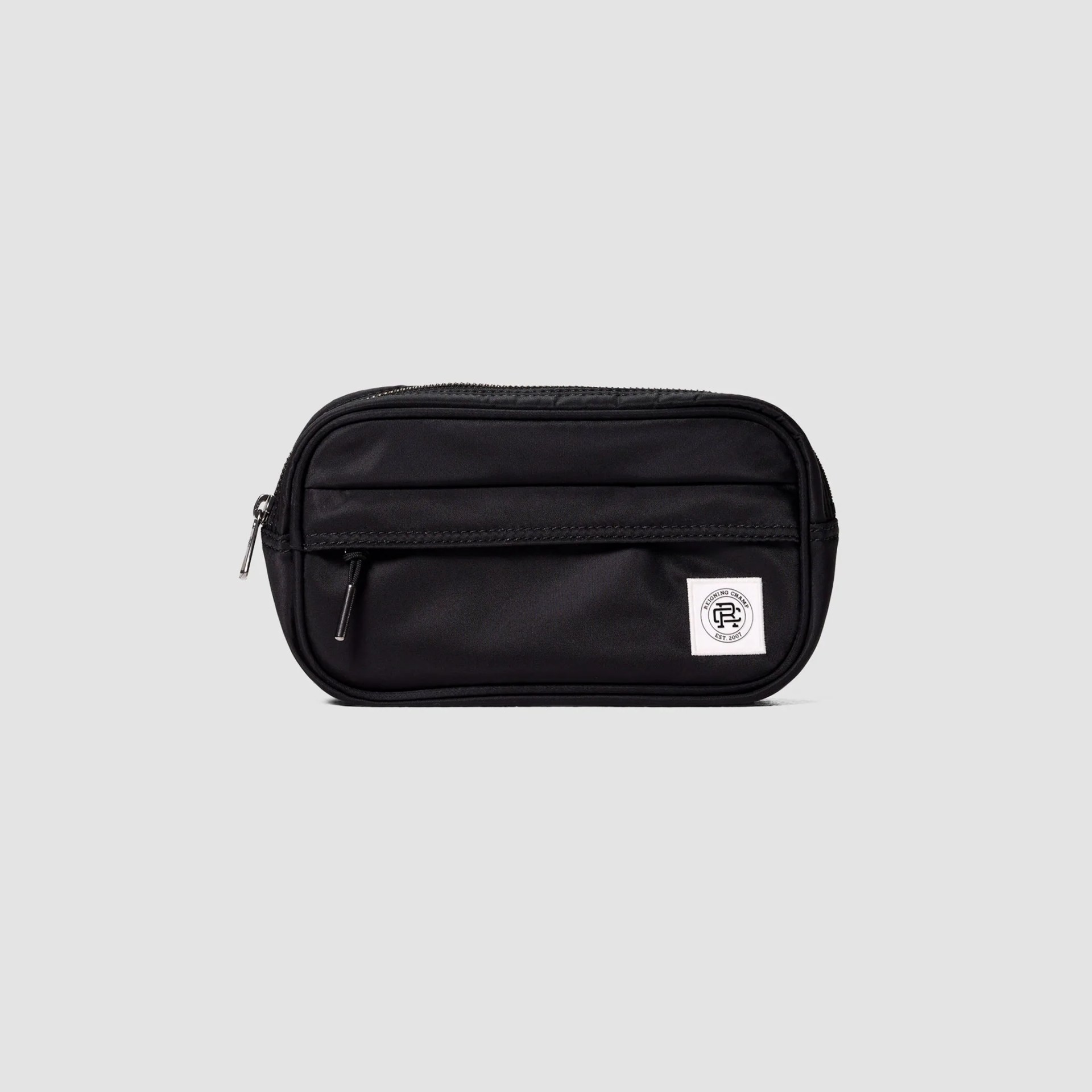 Black rectangular zippered pouch with front pocket and white logo patch on a light gray background.