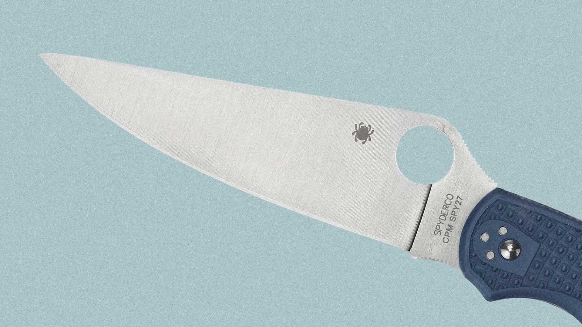Knife blade with Spyderco logo and CPM SPY27 steel marking, blue textured handle on a light blue background.
