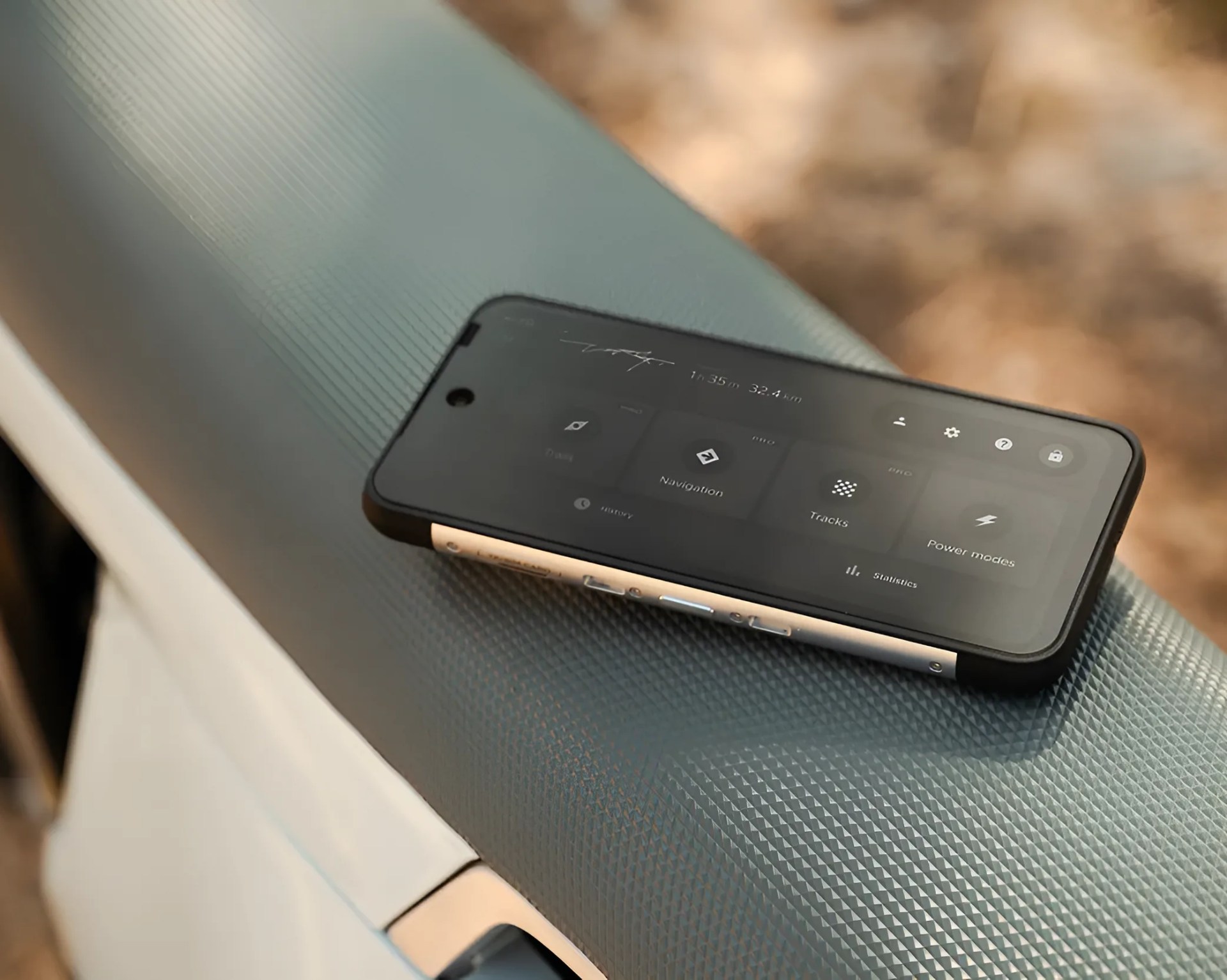 Smartphone with a black case displaying navigation and power mode options, resting on a textured gray surface.