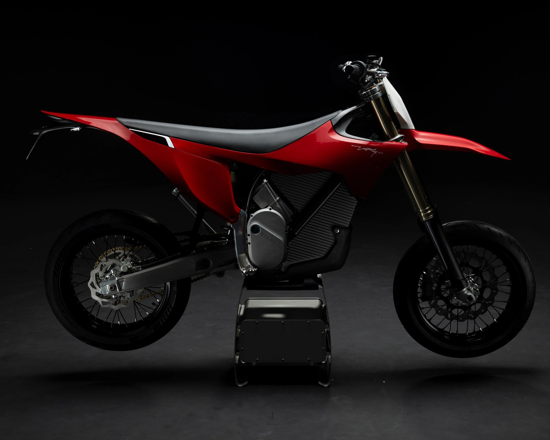 Red and black electric motorcycle with a sleek design on a dark background.