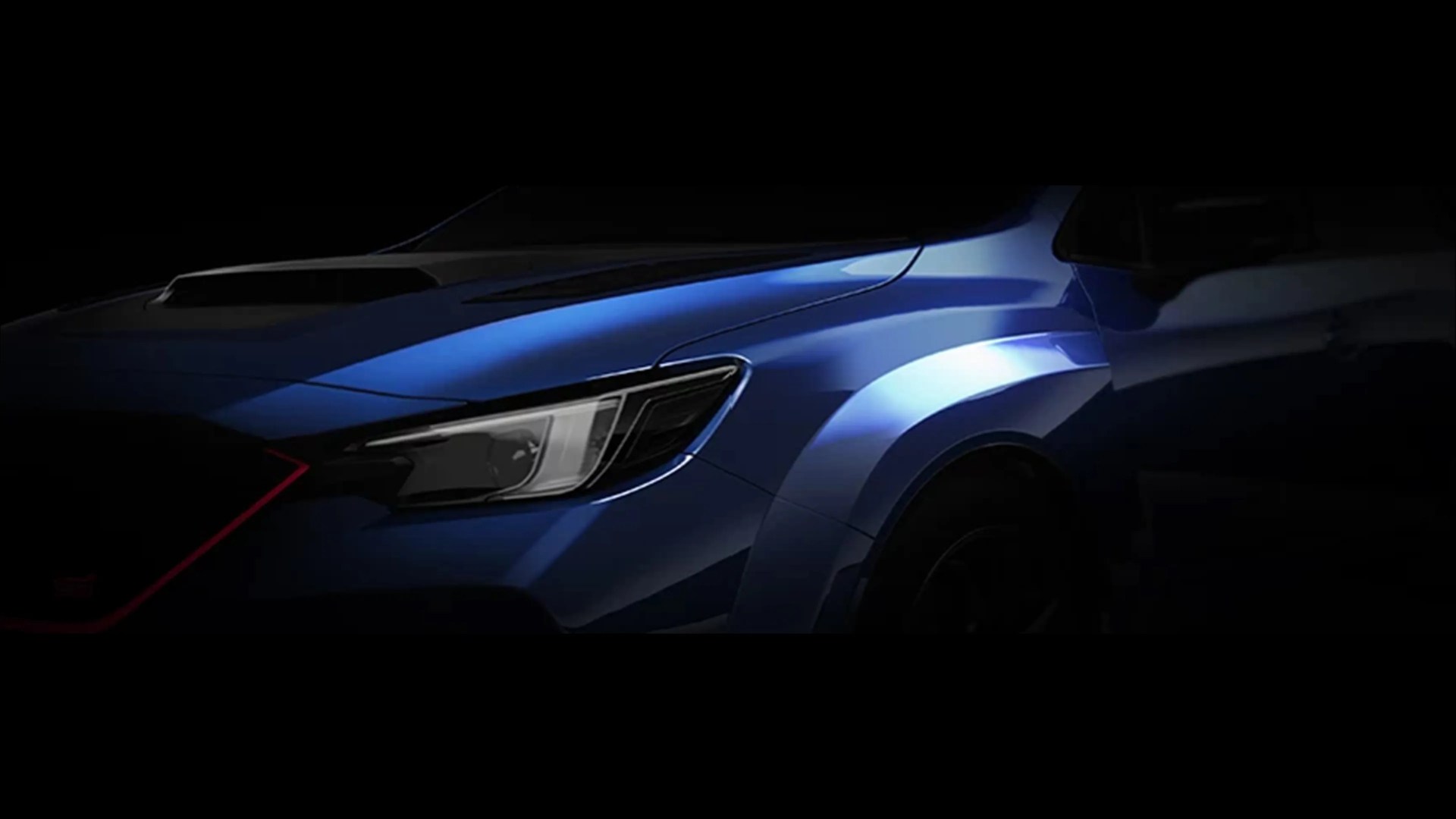 Close-up of a blue car's front left side showing the headlight, hood scoop, and fender with a red accent on the grille.