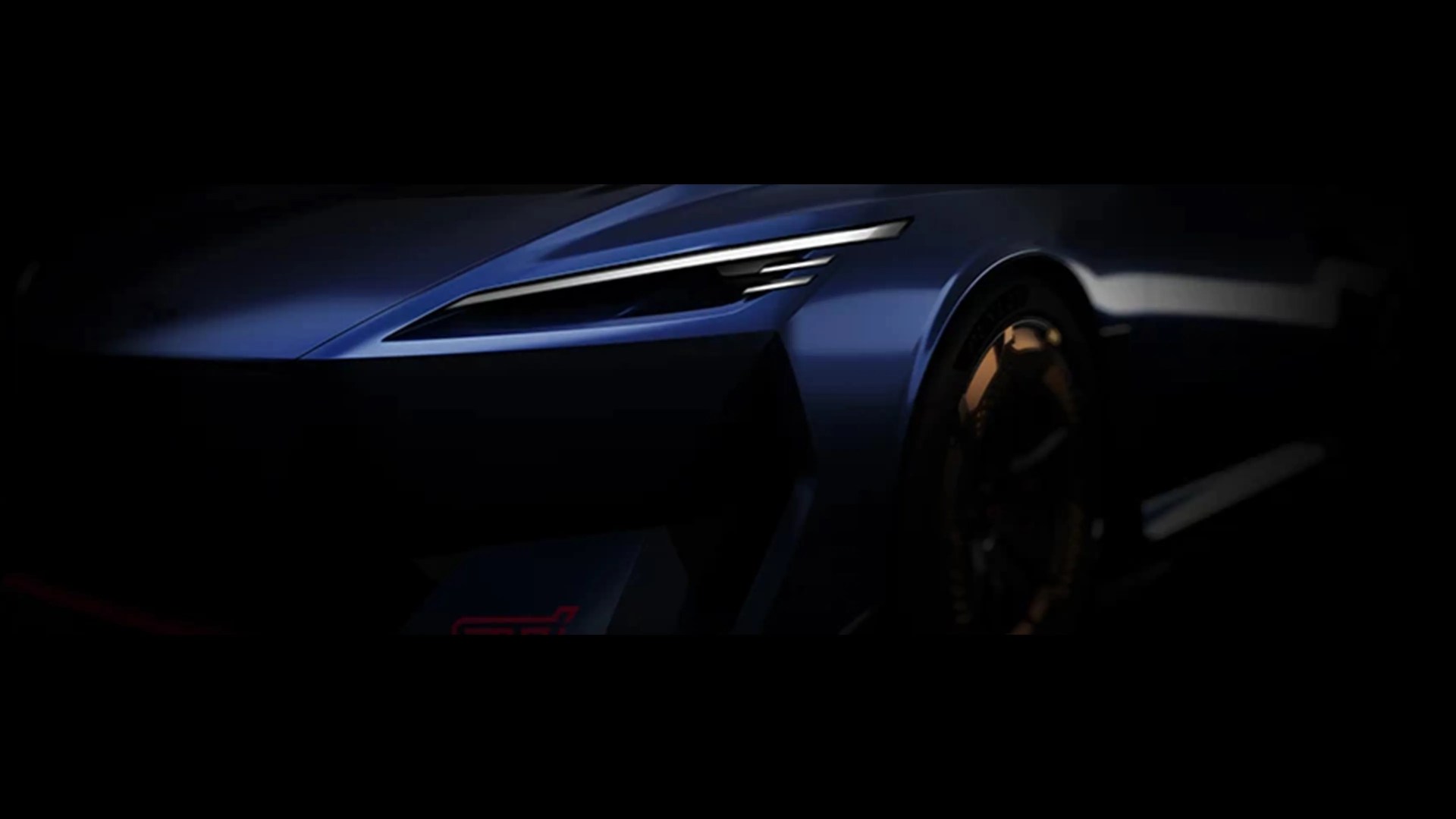 Close-up of a blue car's front left headlight and wheel in low light.