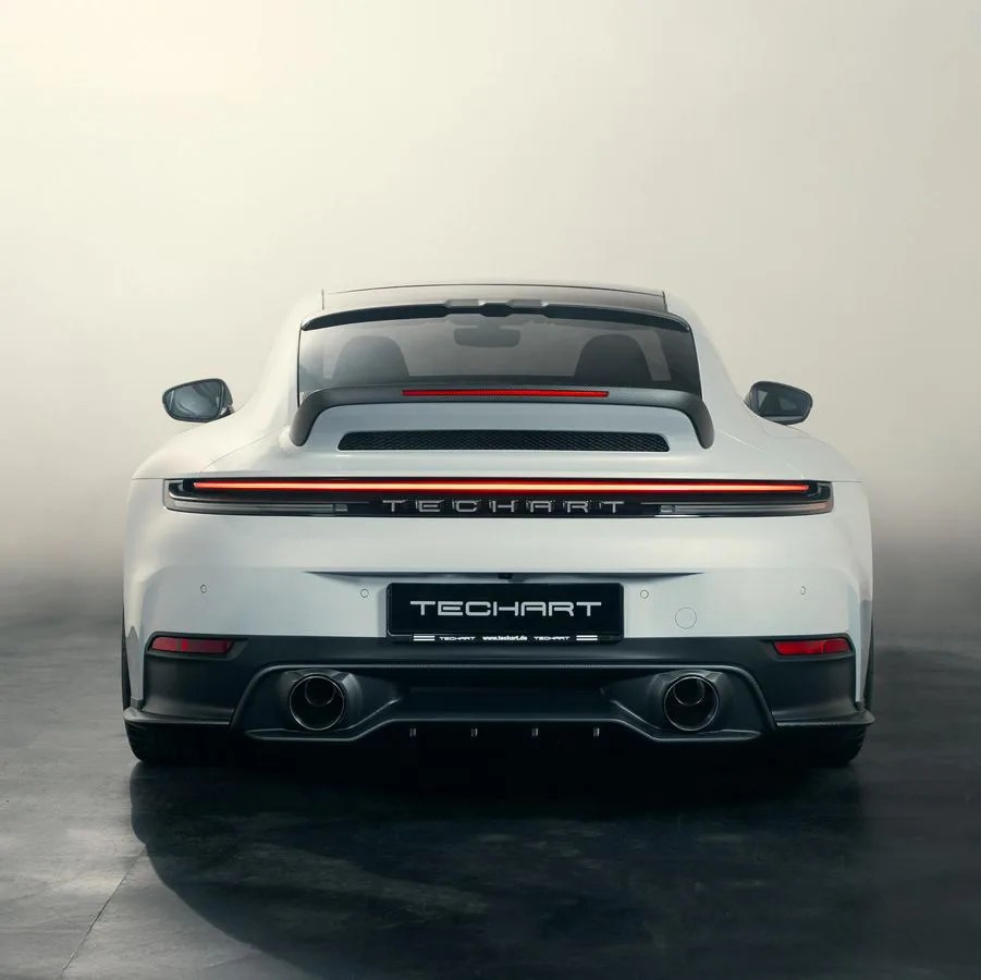 White TechArt sports car rear with black diffuser, dual exhausts, and horizontal LED tail light bar.