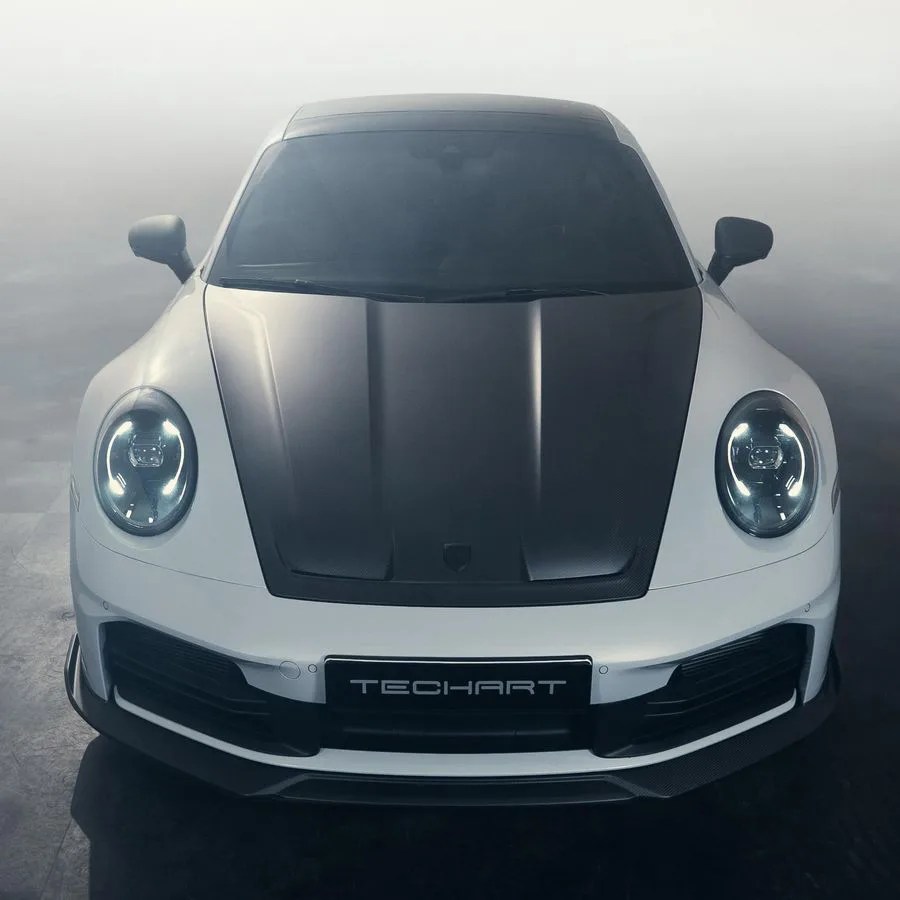 White sports car with a black carbon fiber hood and TECHART license plate, shown from the front.