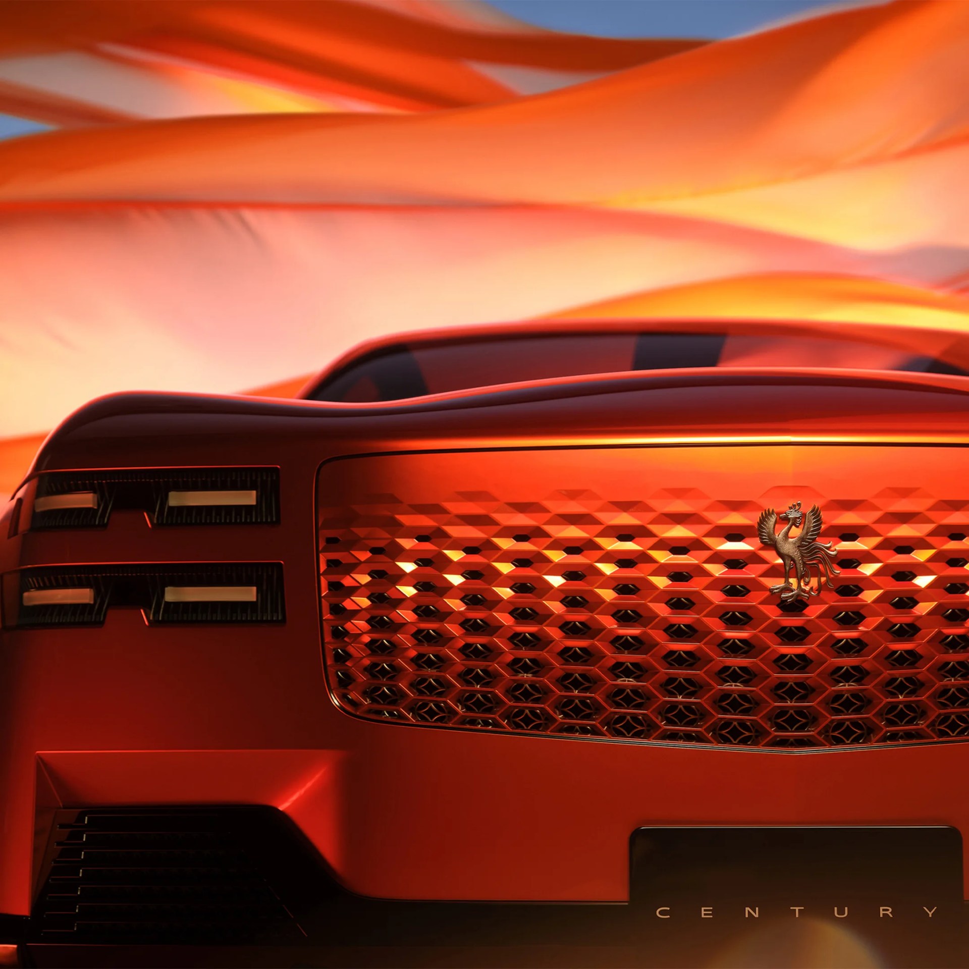 Rear view of a red Century car with a detailed grille and emblem, set against an orange fabric backdrop.